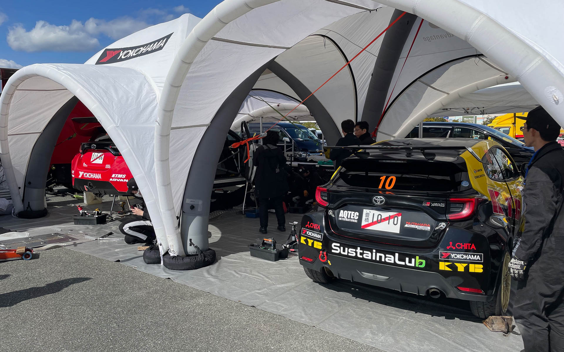ラグーナビーチのサービスパーク。左は奴田原選手のADVANラリーカー、右は石黒/穴井組のKYB号。SustainaLubは新開発で環境に優しいショックアブソーバーの作動油
