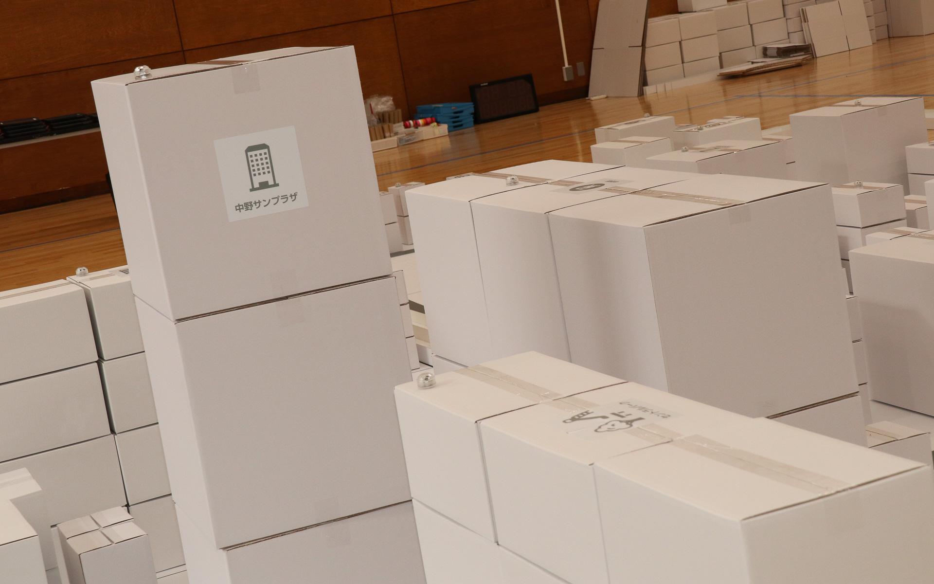 体育館内の7m四方のスペースで再現された“ミニチュア中野区”。白いダンボールを使って組み立てられ、子供たちが自由なアイデアを書き込んでいけるキャンバスとなっている