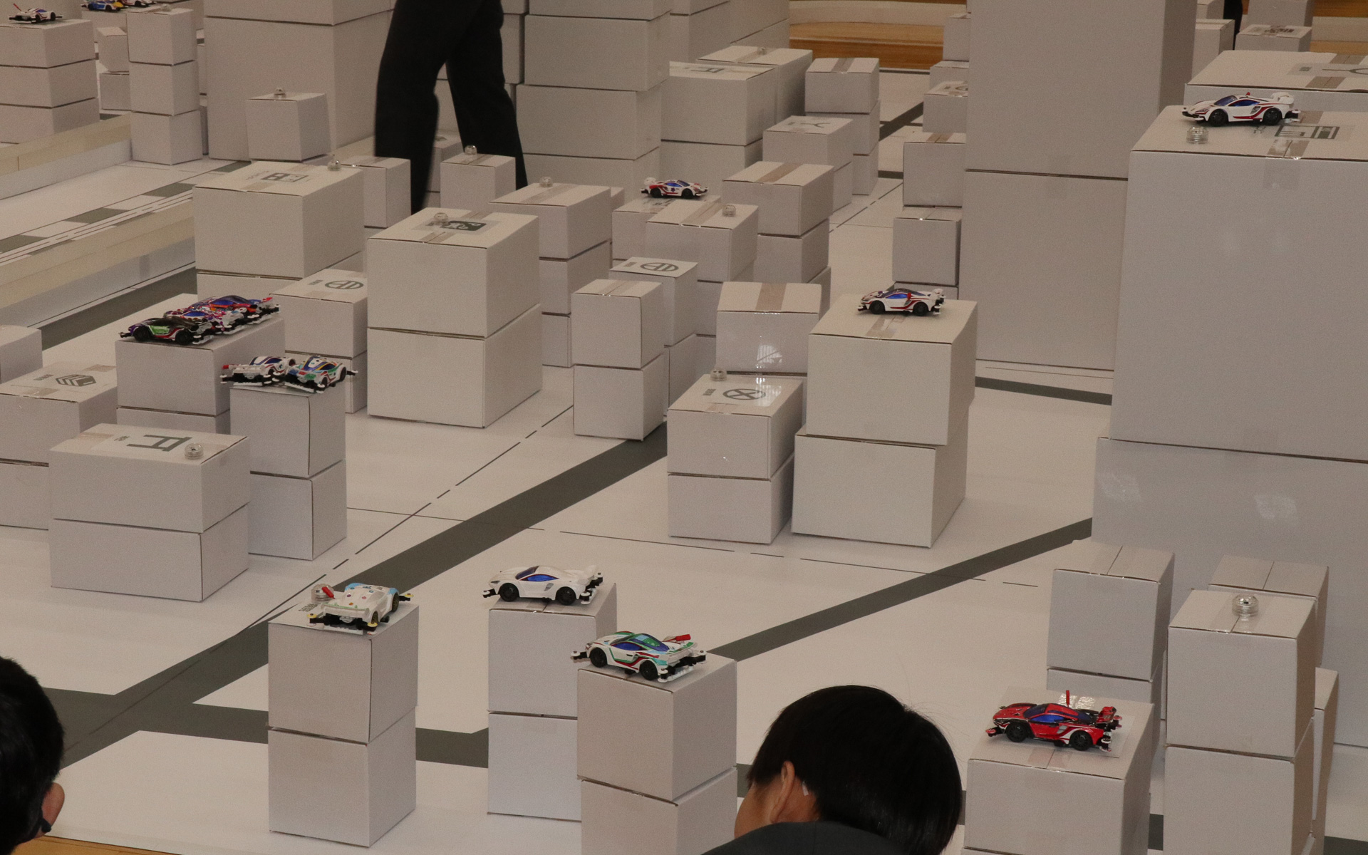 子供たちが“ミニチュア中野区”を歩きまわり、電気が必要そうな施設に自分のミニ四駆を設置していく