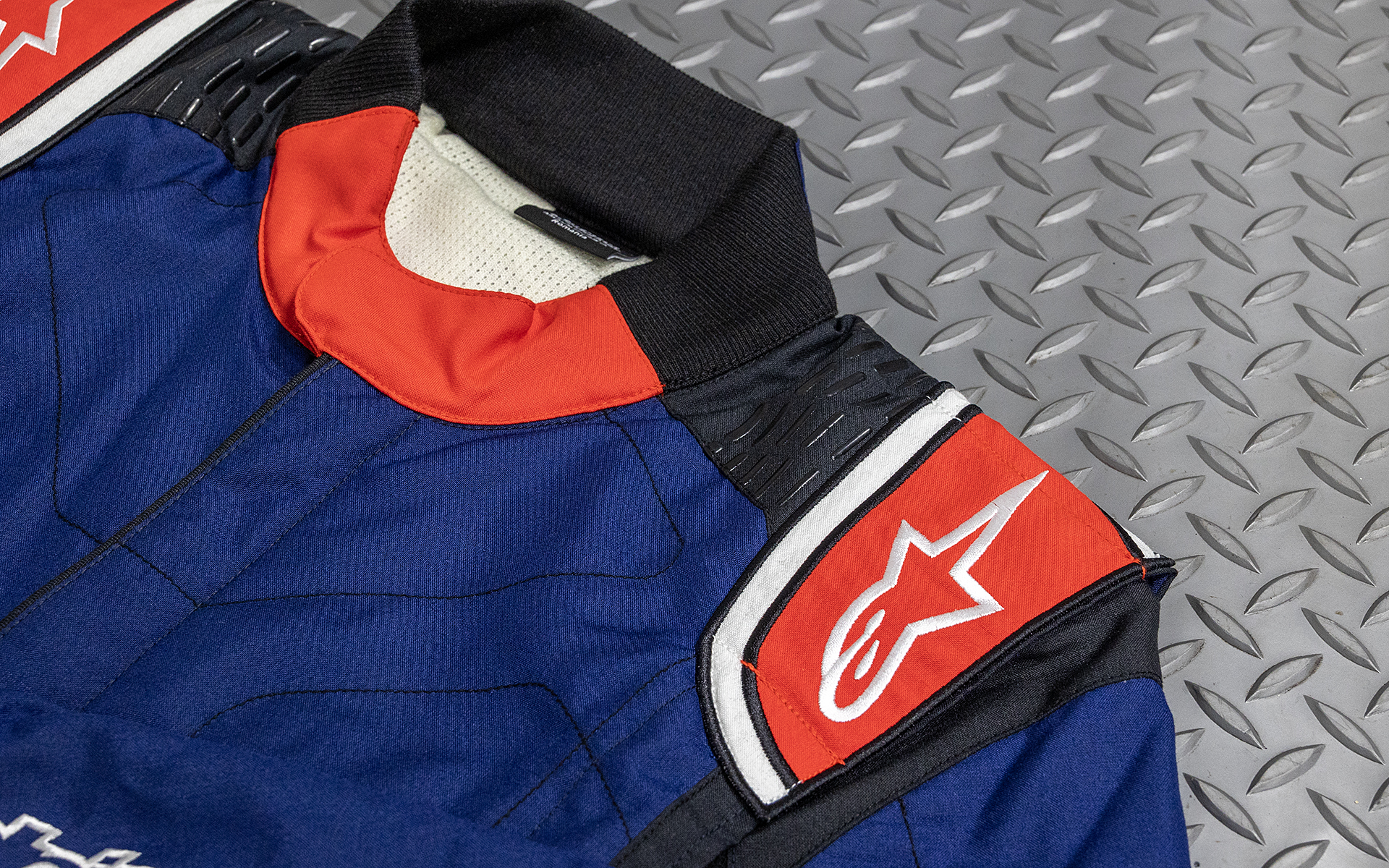 HANSがずれないようにするためのシリコングリップテクノロジーを採用。HANSも安全性向上のためアマチュアドライバーの装着率が上がっているレーシングギアの1つ