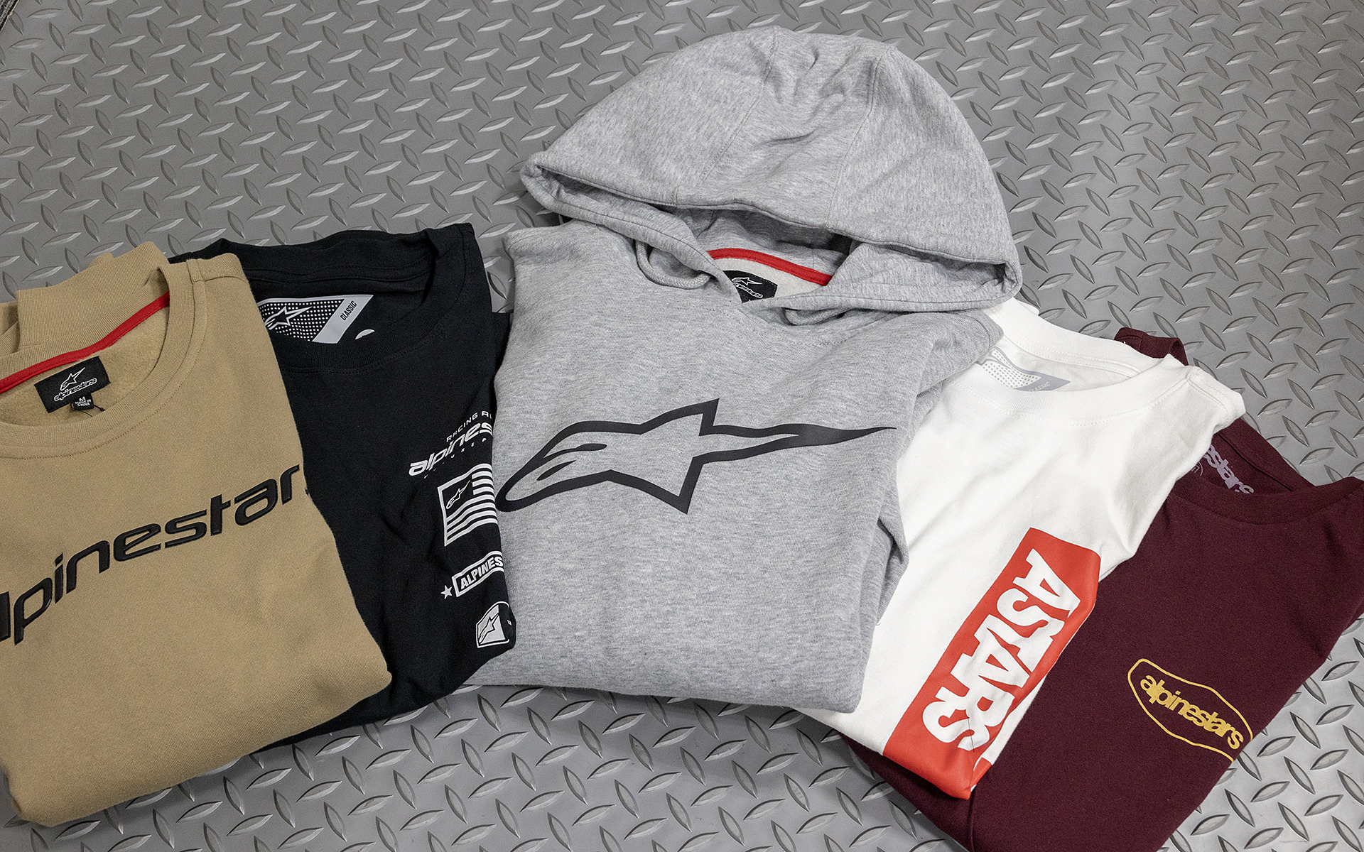 アルパインスターズは、フーディーやトレーナー、Tシャツなどのアパレルもラインアップしている。レーシングスーツ同様にデザインセンスの高い製品がそろっていて、全国のアルパインスターズ製品取扱店で購入できる。販売店のリストは<a href="https://cuspa-spk.jp/alpinestars/store-list/" class="n" target="_blank">【アルパインスターズWebサイト】</a>を参照いただきたい