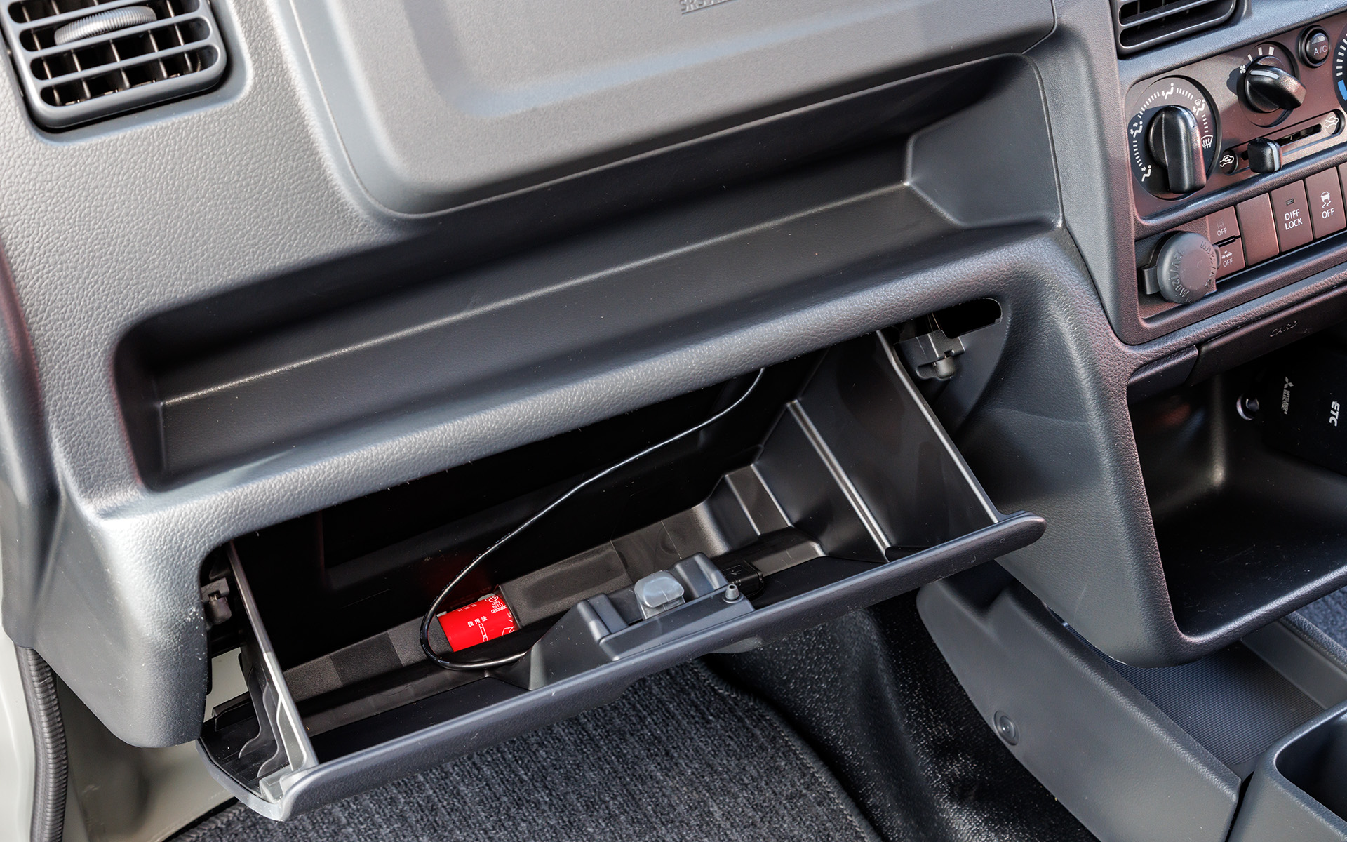 助手席側にはワイドなトレーとグローブボックス。中にあるケーブルはナビゲーションのUSB接続用