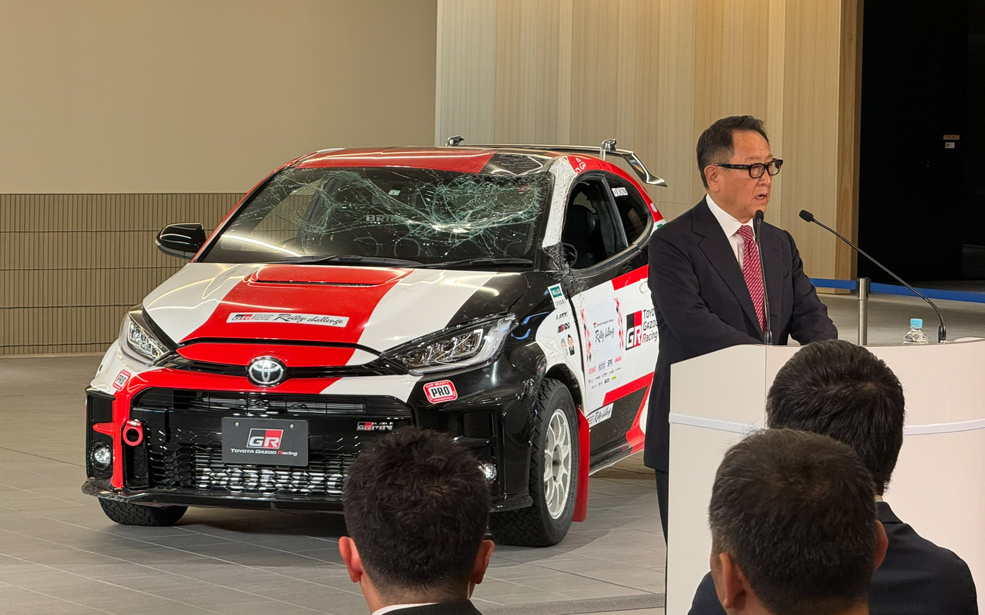 横転して壊れたGRヤリスとともにあいさつをする豊田章男会長。クルマ屋としての覚悟を感じるあいさつだった