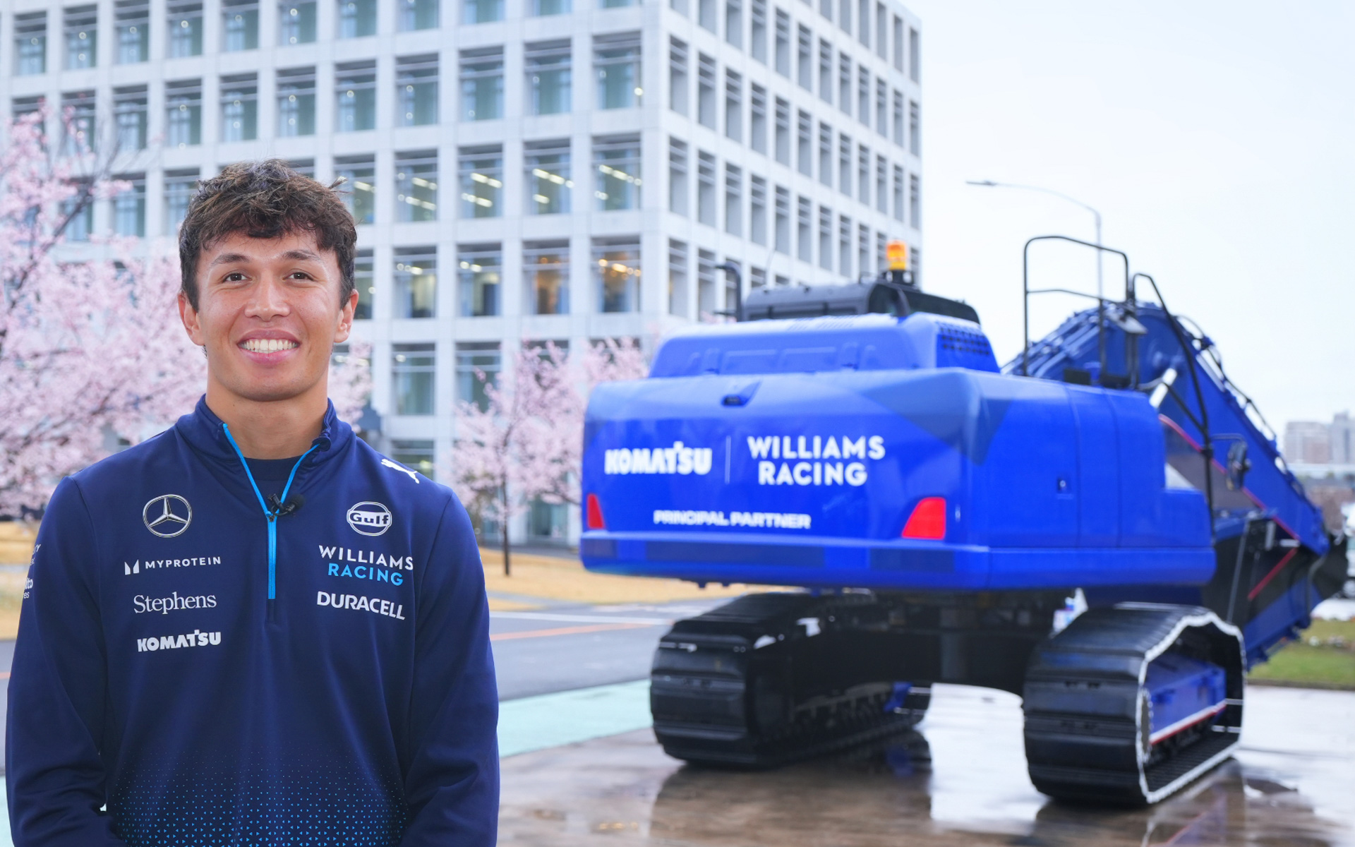 ウィリアムズ・レーシングのマシンカラーに特別塗装をした油圧ショベル「HB205-2」とアレックス・アルボン選手