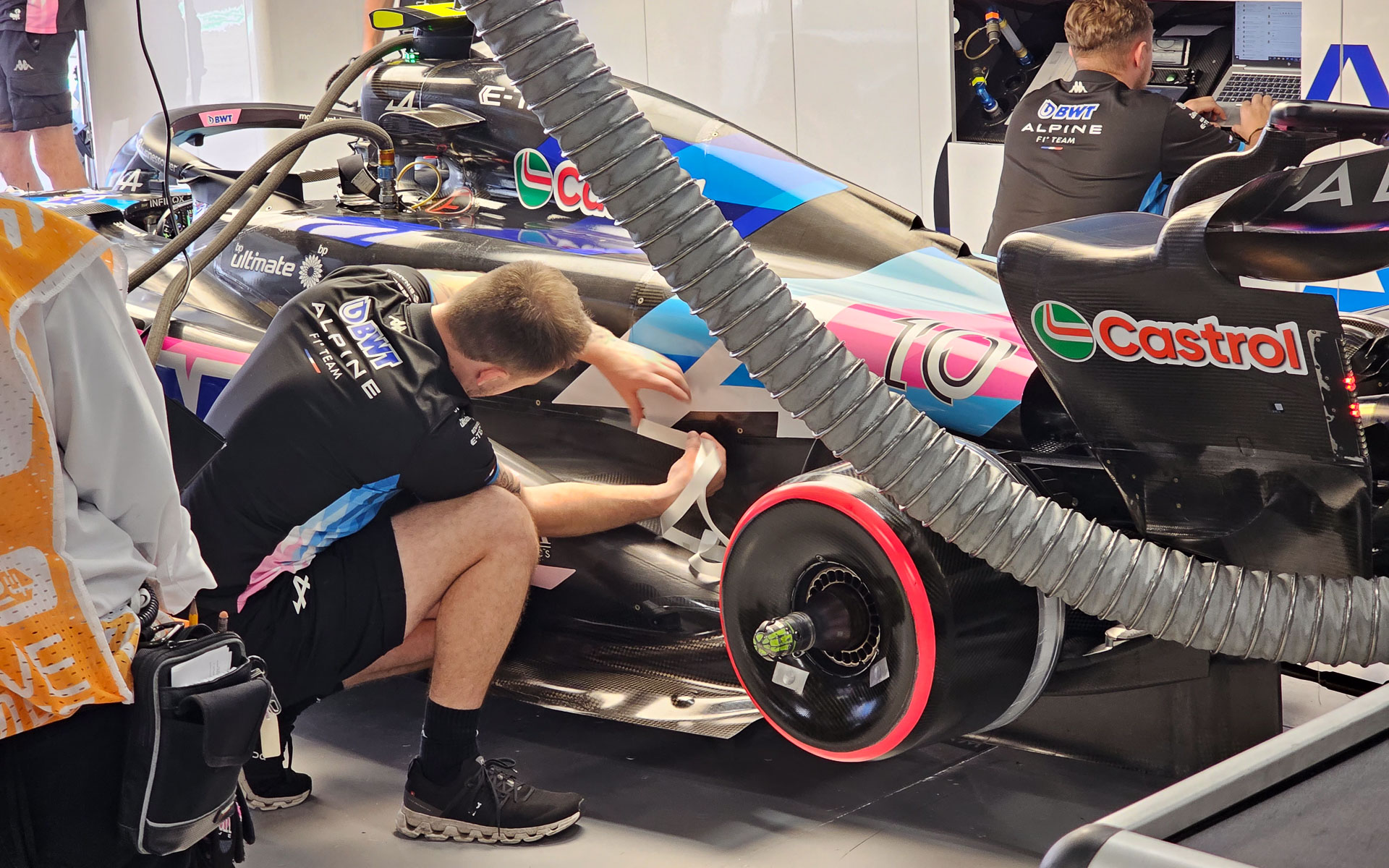 レース前に向けた作業、メカニックは透明なシールをカウルに貼って、カウルがはがれないようにしている