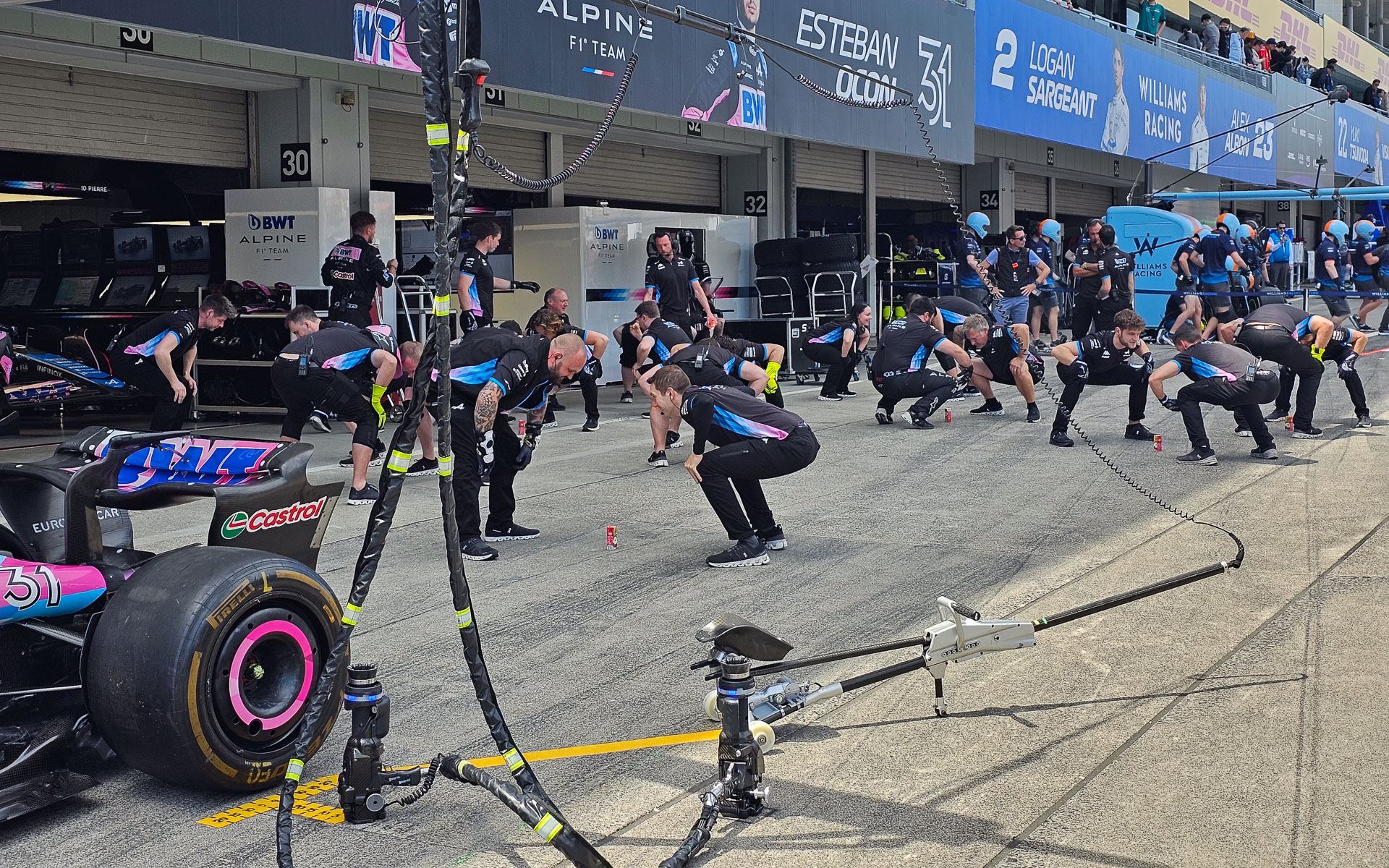 メカニックが柔軟体操を行なっている