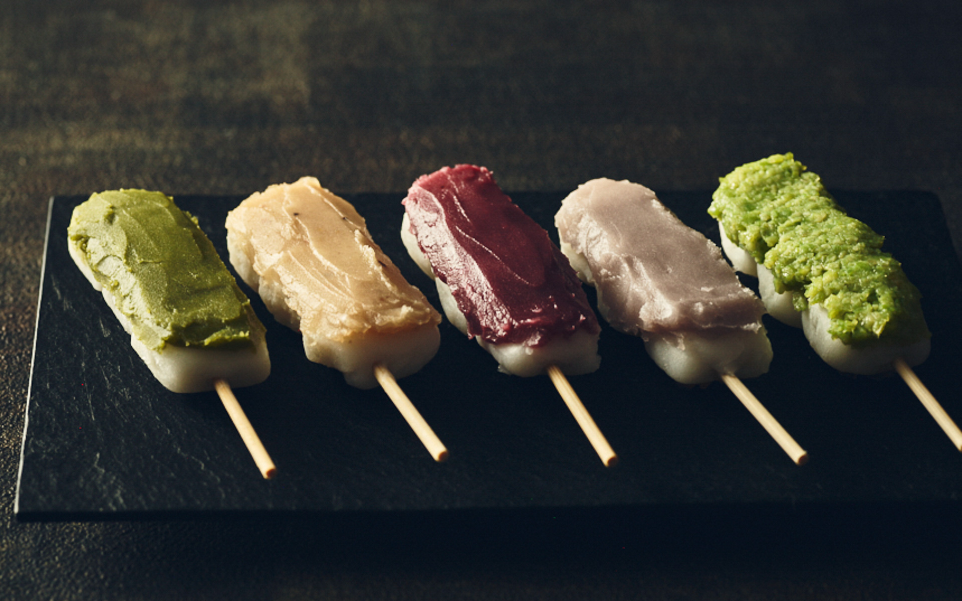 日比谷 五街道団子（5種1300円/3種800円）。東海道（静岡）をイメージする抹茶餡、中山道（長野）をイメージする栗餡、日光街道（栃木）をイメージするいちご餡、甲州街道（山梨）をイメージする赤ワイン餡、奥州街道（宮城）をイメージするずんだ餡の5つの色と味わいで、お皿の上で旅気分を楽しめる