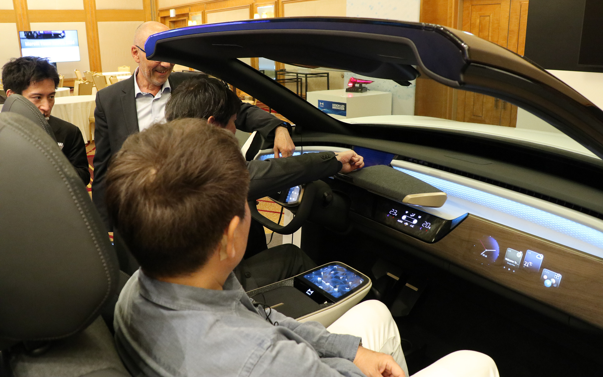 側面からは見えないが、フルディスプレイメーターの手前側に表示された自身のアバターを触ろうとしているシーン