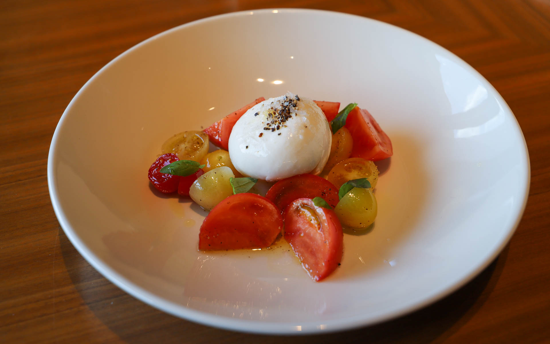 シンプルなカプレーゼにもこだわりが込められており、地元七富チーズ工房のモッツァレラチーズに、地元産のアメーラトマト（静岡の方言で“甘い”のことを“あめえら”ということから名付けられたとても甘いトマト）、静岡産のオリーブオイルを使用。さらに、添えられるバジルは夏になるとホテル内の畑で育ち、シェフが朝摘みしたバジルになるとのこと