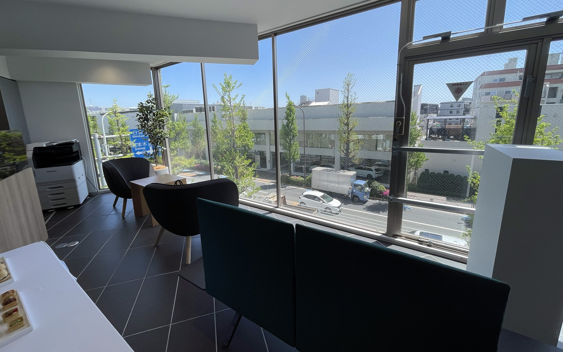 白を基調にしたショールーム。1階に駐車場と新車展示場、2階に接客エリアを備えたショールーム、3階にサービス受付を構える