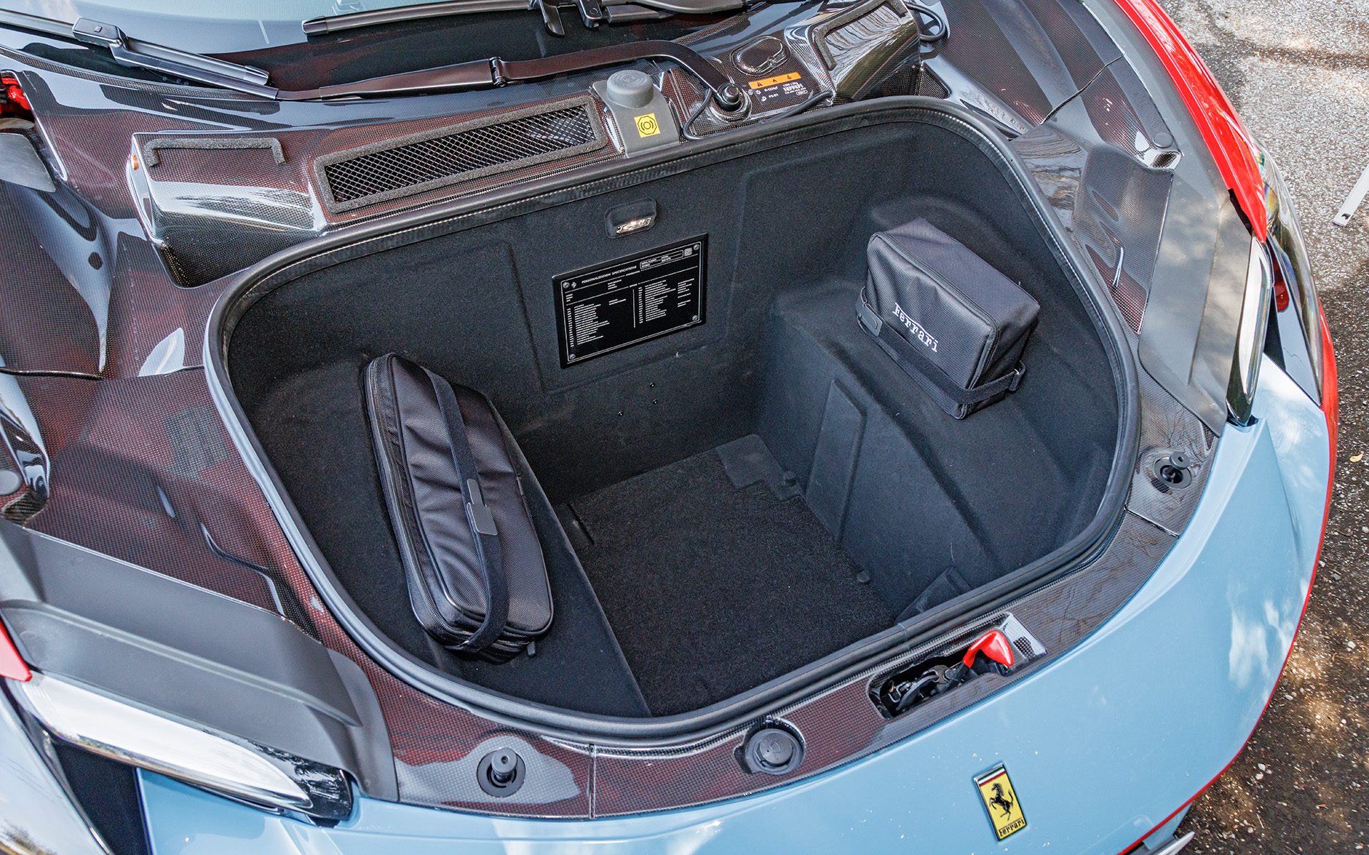 フロントフードの下には収納スペースを用意。充電用コードなども収められている