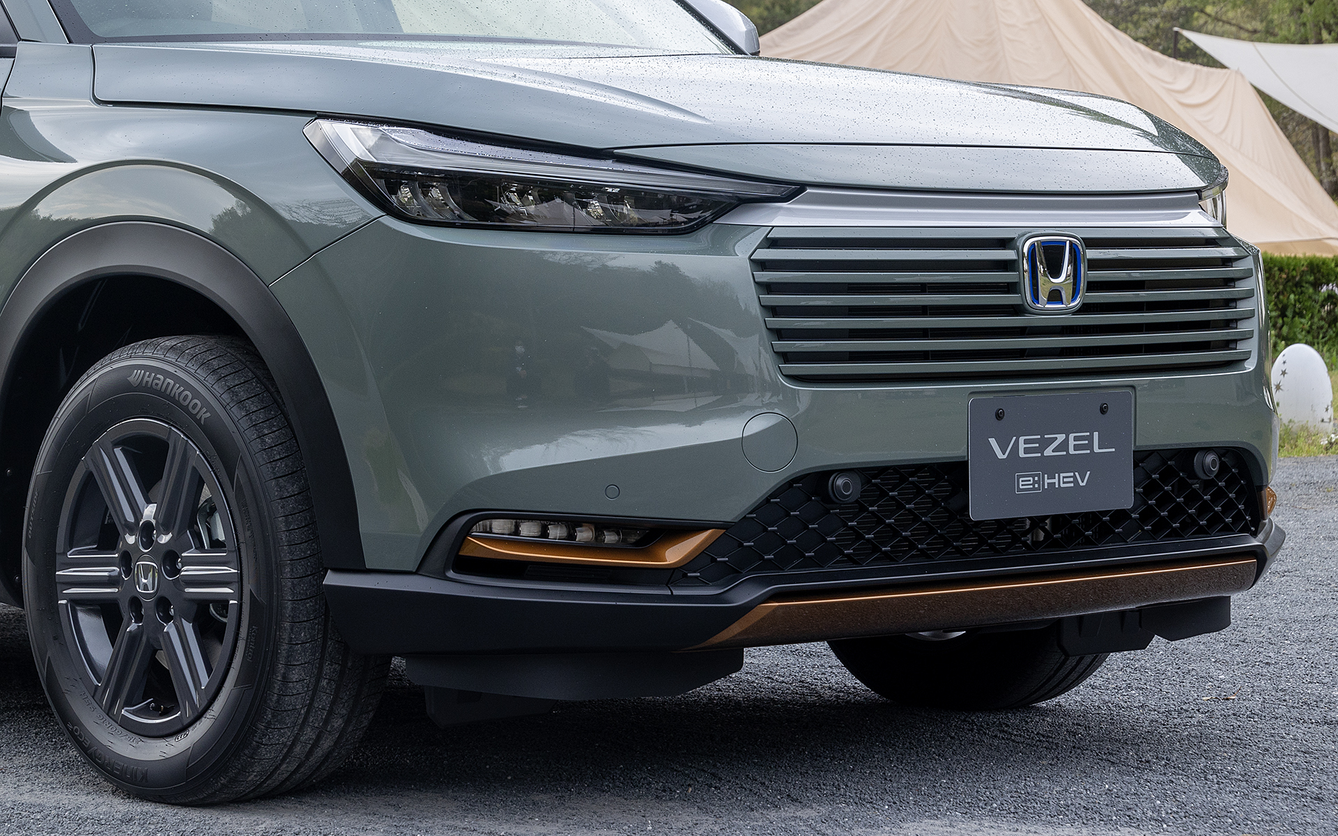 e：HEV X ハントパッケージではグリル上部の加飾がマットなシルバー系となる。また、グリルは下部に絞り込みが入ったことで小顔化された印象になった。フォグライトガーニッシュとバンパー下部にはカッパー・メタリックの加飾が入った