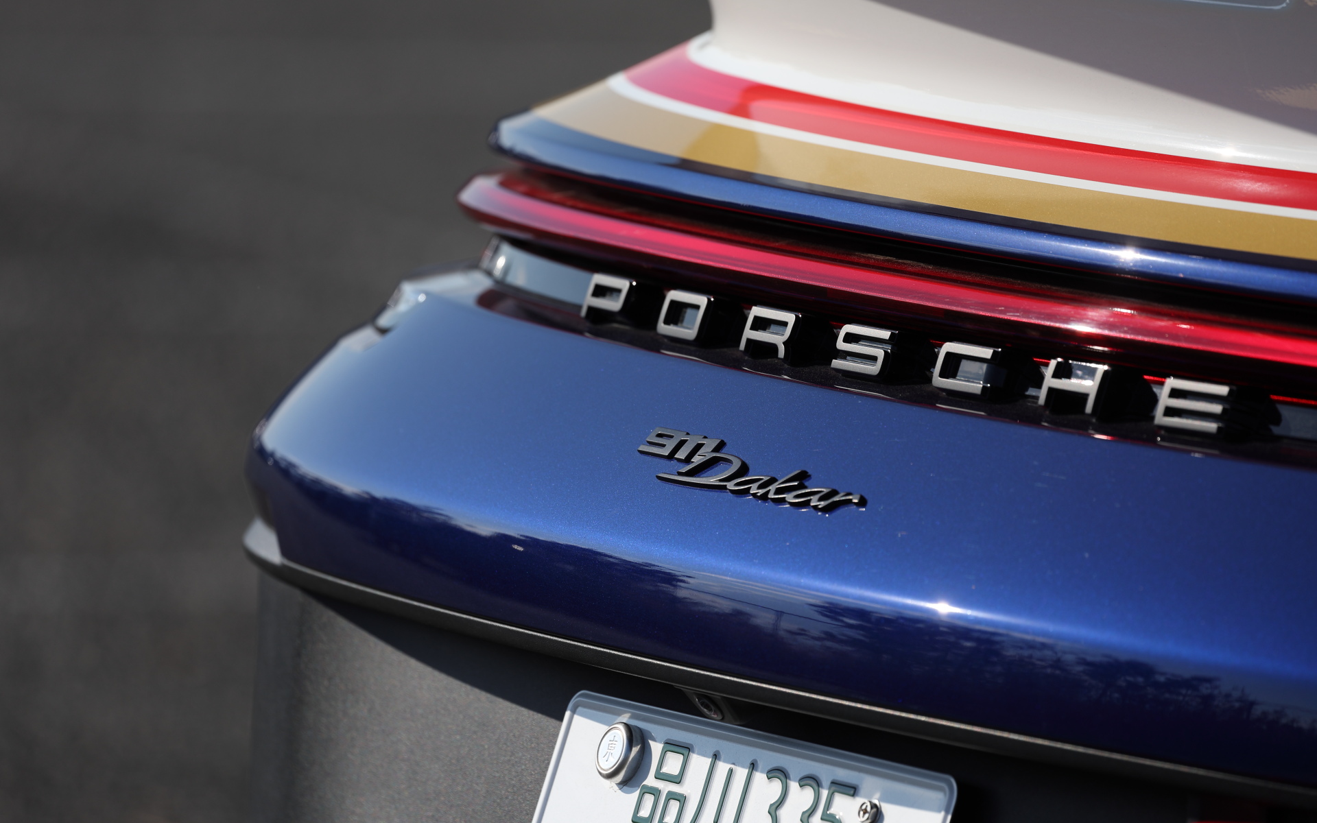 撮影車両はオプションの「ラリーデザインパッケージ」（390万3000円）を装着。1984年パリ-ダカールラリーの優勝車の外観を再現した911ダカールのラリーデザインパッケージ仕様車は、レッドとゴールドのデコレーティブストライプに加えてドアに登録商標されている“Roughroads（ラフロード）”ロゴがあしらわれる。さらにロールオーバーバー、6点式シートベルトを備えた「ラリースポーツパッケージ」（52万4000円）も装着する