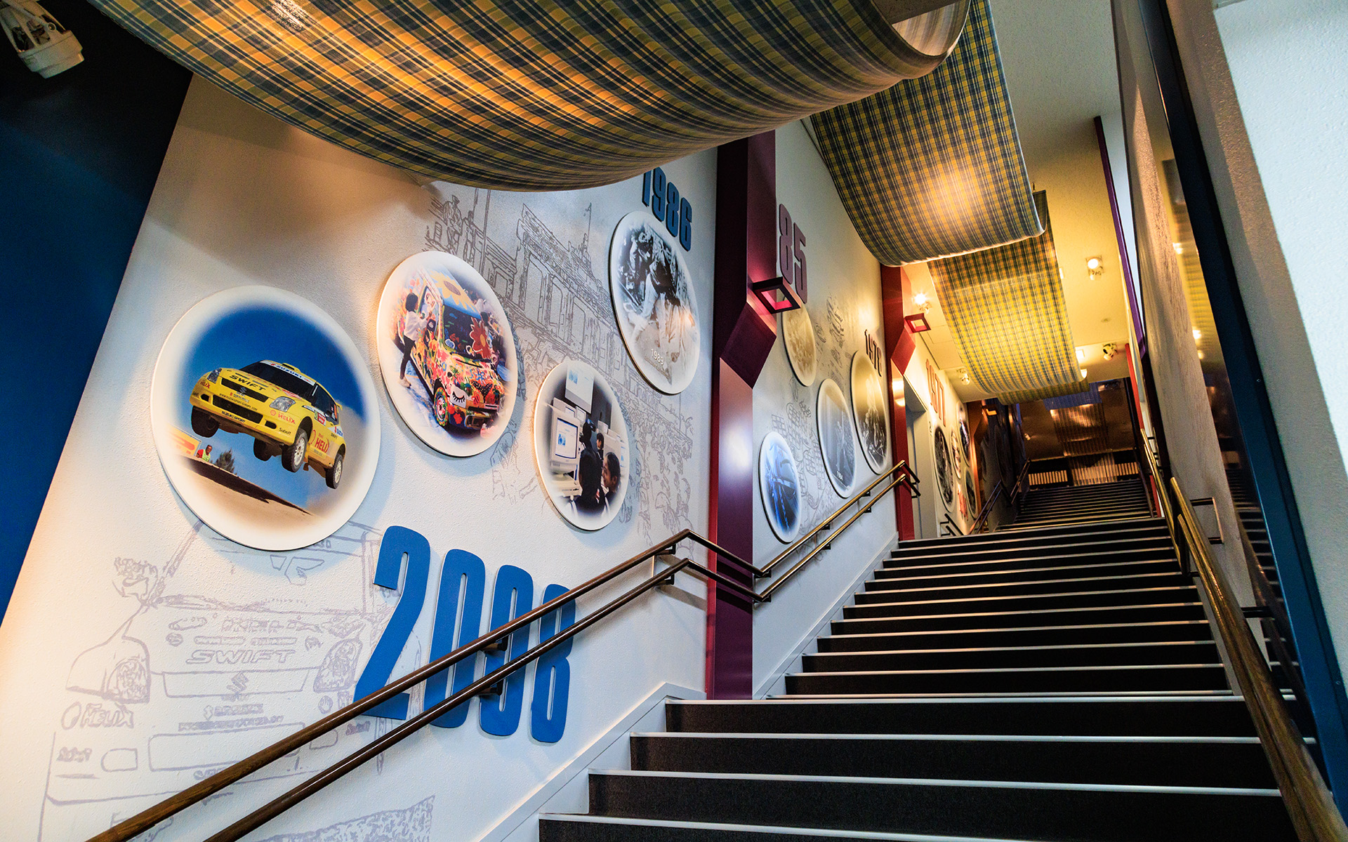 階段の天井には自動織機まで続く織物が飾られる