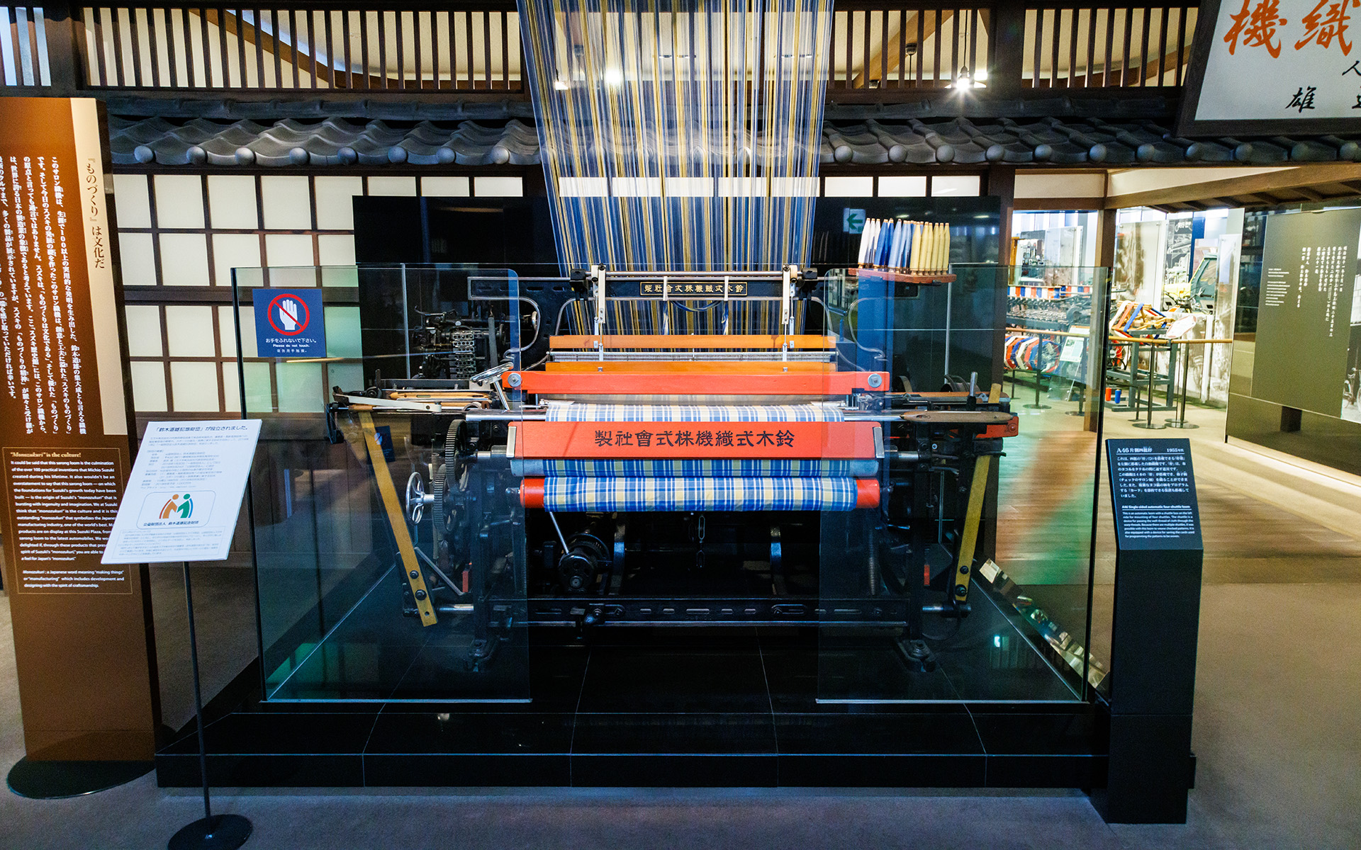 階段の天井には自動織機まで続く織物が飾られる