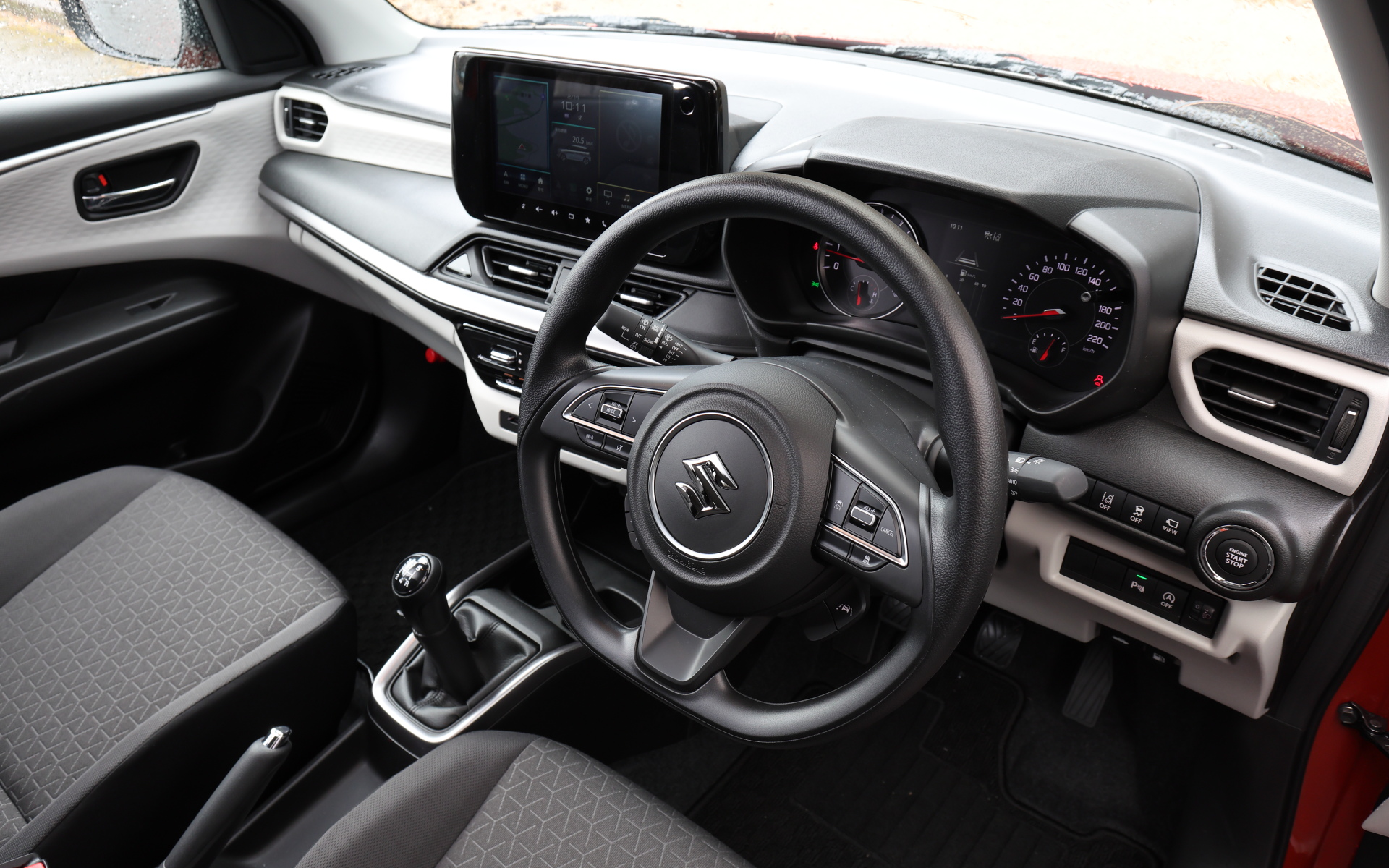 ウレタンステアリングホイールと、メランジグレー＆ブラックのシート表皮を採用する5速MTモデルのインテリア。CVTモデルと異なりセンターアームレストは採用されていない