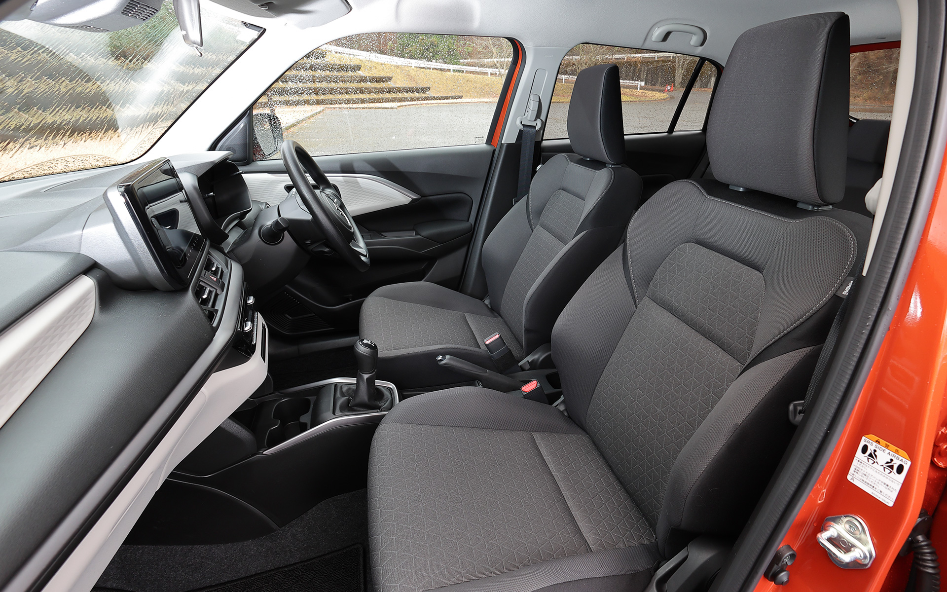 ウレタンステアリングホイールと、メランジグレー＆ブラックのシート表皮を採用する5速MTモデルのインテリア。CVTモデルと異なりセンターアームレストは採用されていない