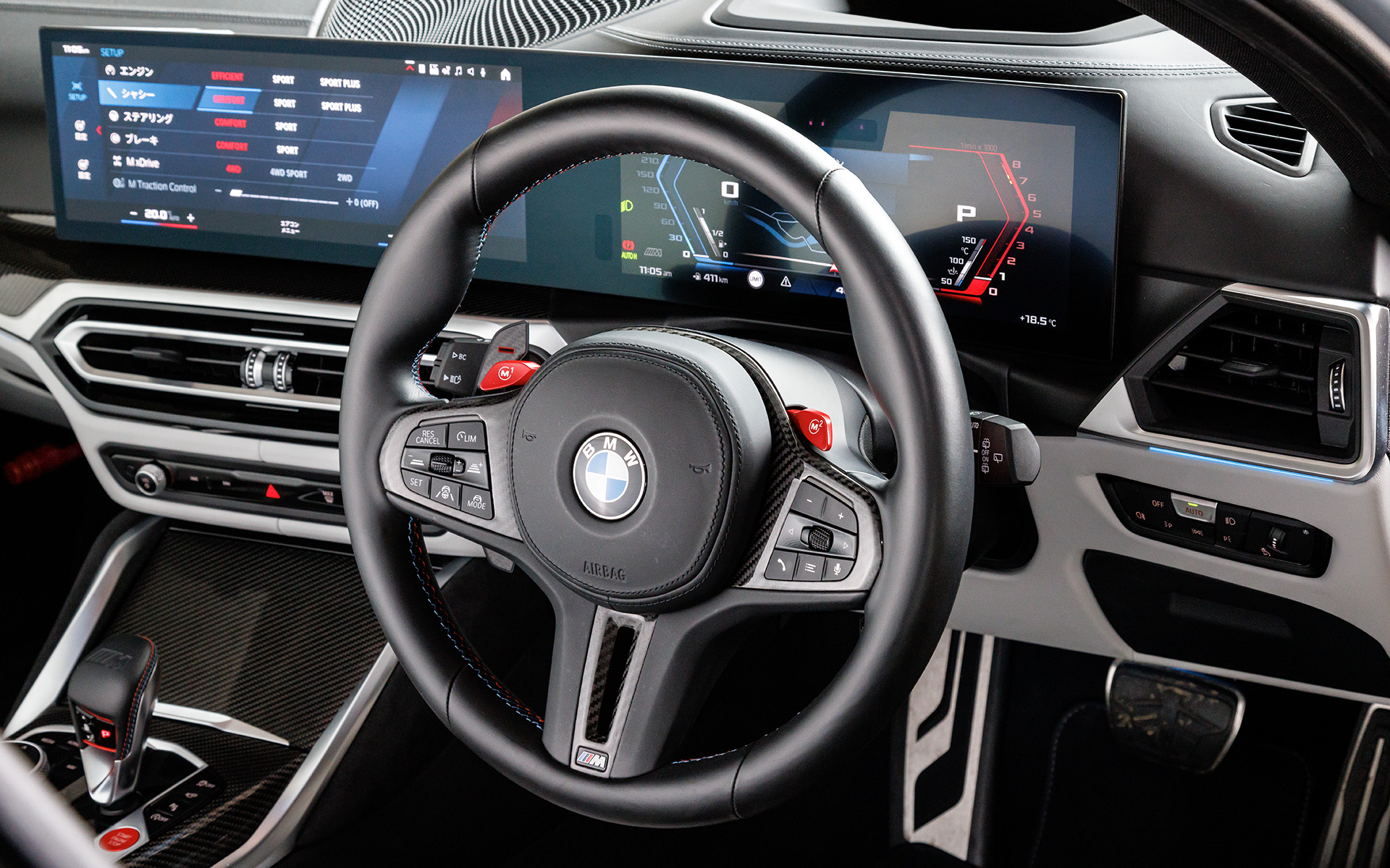 ステアリングはカーボンのパドルなどスポーツ感盛り盛り。赤いMのスイッチは画面上で設定変更を行なうためのショートカットキーのような役割
