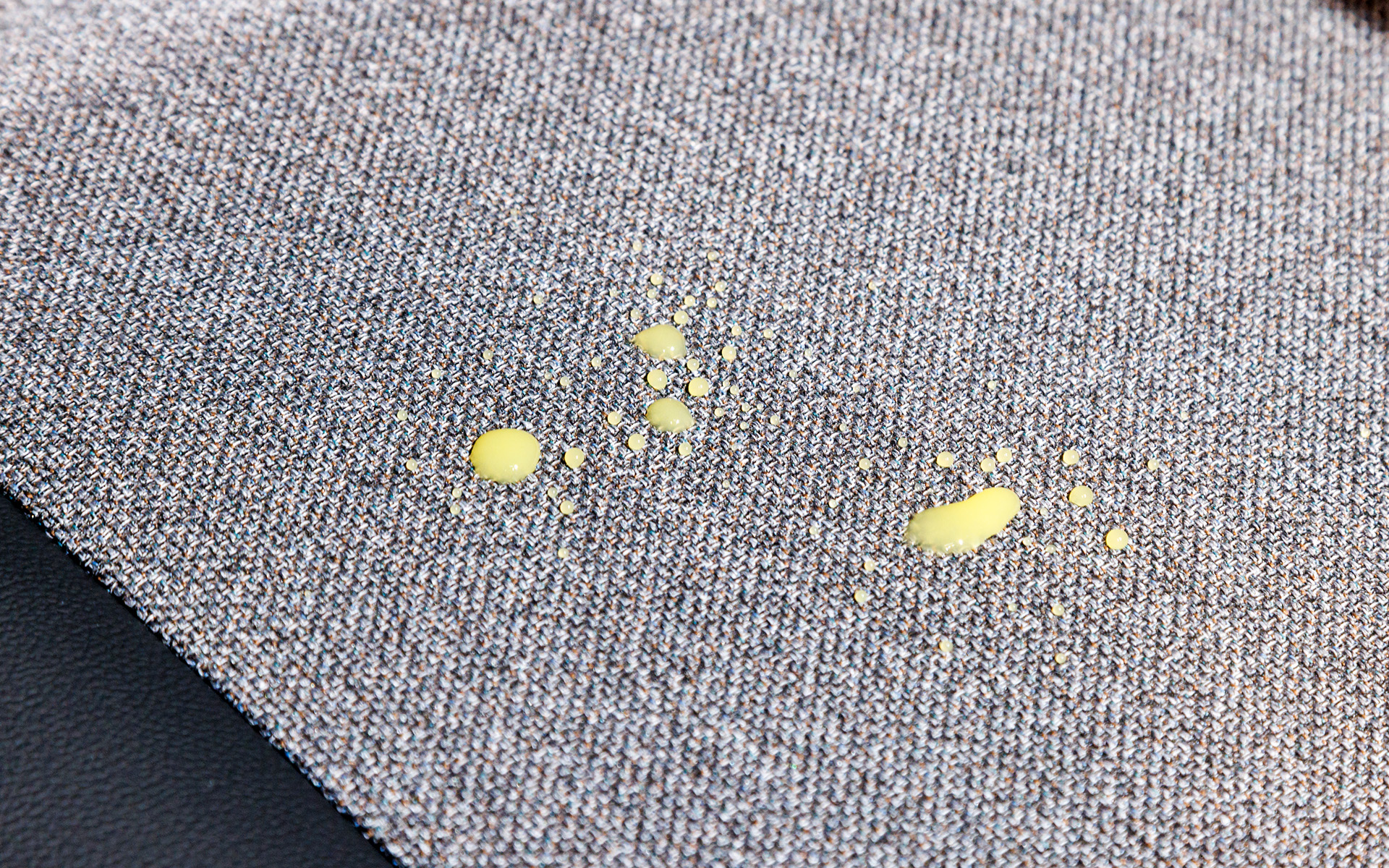 シート表皮には撥水、撥油性ファブリックを採用。オレンジジュースをこぼしても写真のようにはじくのでカンタンに拭き取りが可能