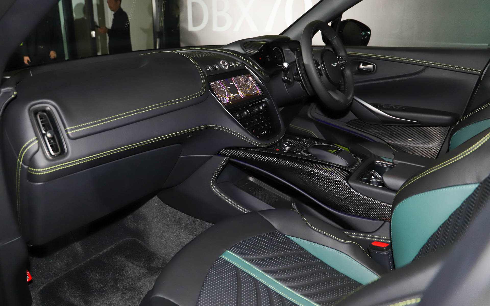 カーボンをふんだんに用いたスポーツインテリアインスパイア・スポーツ・デュオトーンインテリア。シートはアストンマーティンらしいグリーンを用いたオニキスブラック/アイフェルグリーンレザー。車内各所にライムカラーのアクセントステッチがあしらわれる