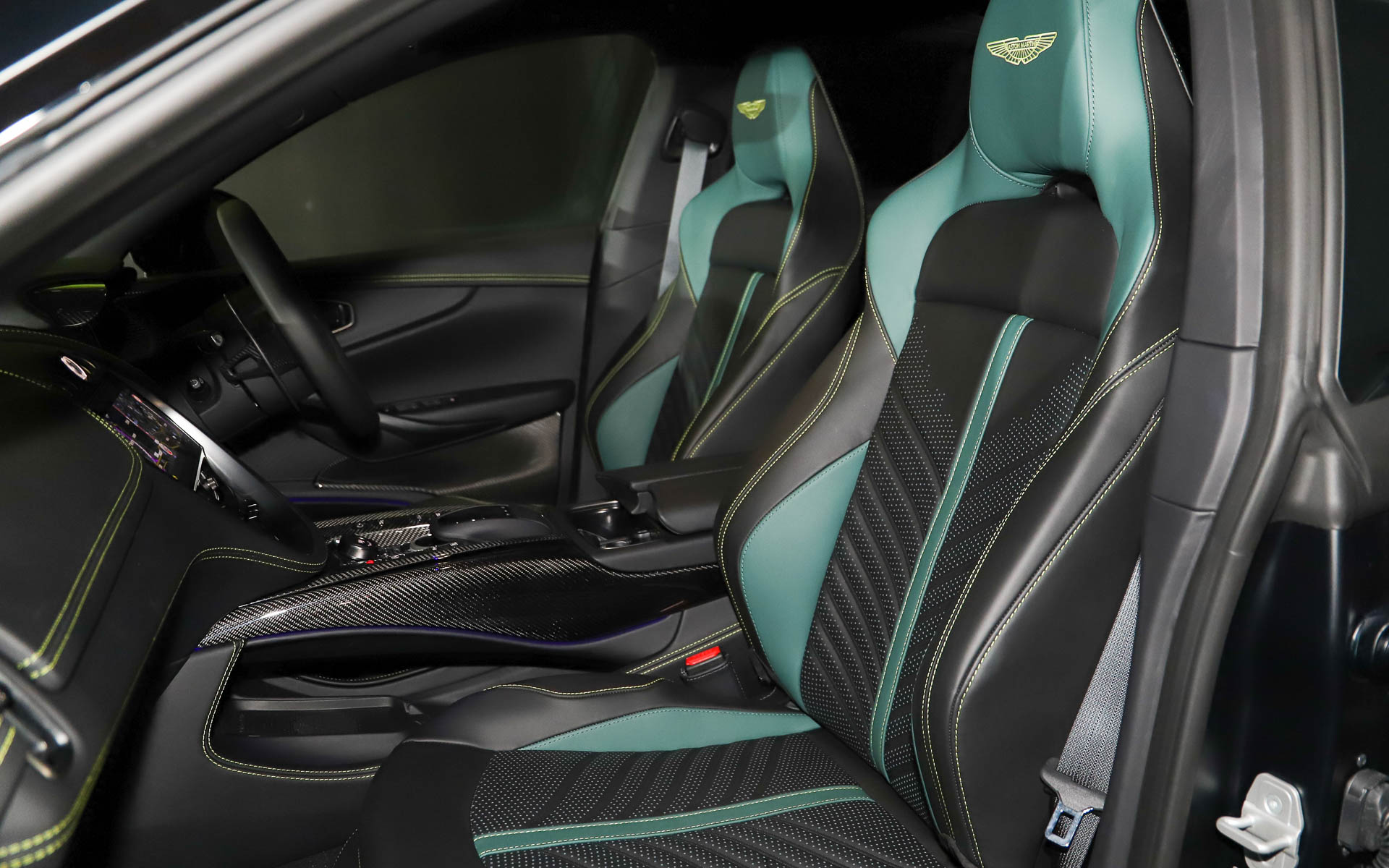 カーボンをふんだんに用いたスポーツインテリアインスパイア・スポーツ・デュオトーンインテリア。シートはアストンマーティンらしいグリーンを用いたオニキスブラック/アイフェルグリーンレザー。車内各所にライムカラーのアクセントステッチがあしらわれる