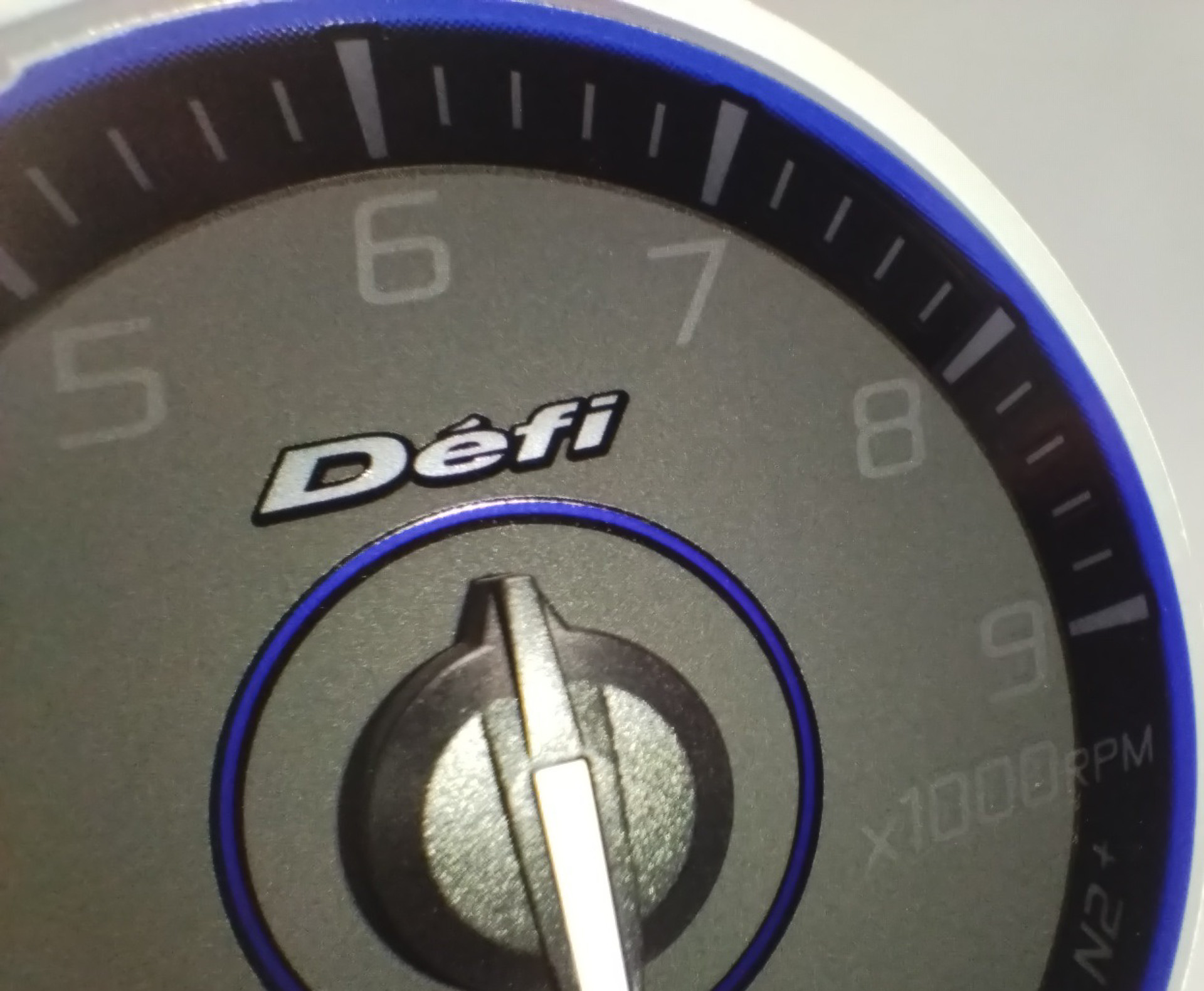 Defiロゴにシルバーミラーインク、中心部の意匠にカラーのミラーインクを新採用。Defi最上位機種「ADVANCE A1」のデザインをリスペクトした、艶黒×艶消し黒のコンビ印刷を用いた