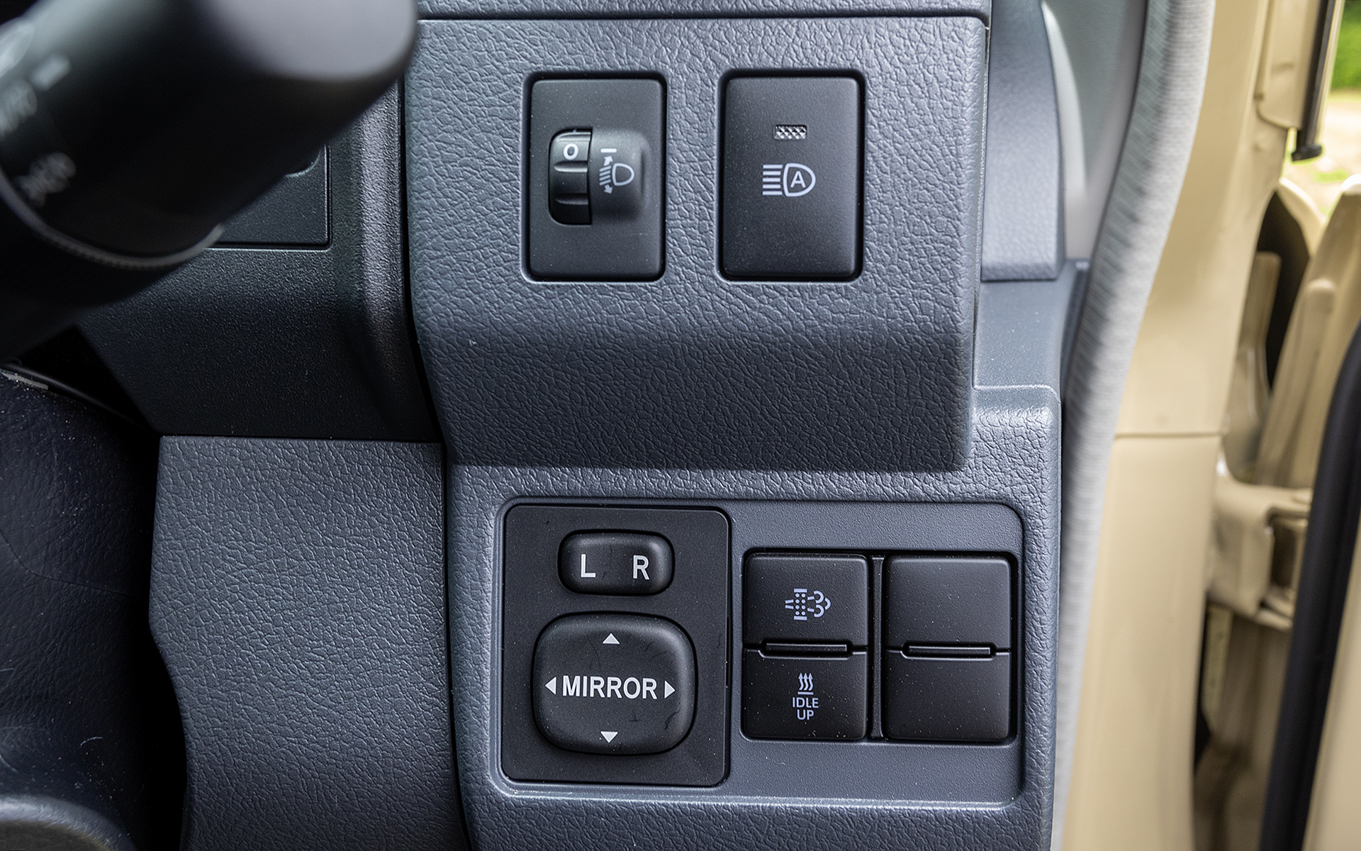 ダッシュボード右側にあるスイッチ。光軸調整、オートマチックハイビームのON/OFFスイッチ。サイドミラー調整、排出ガス浄化スイッチ、アイドルアップスイッチが並ぶ