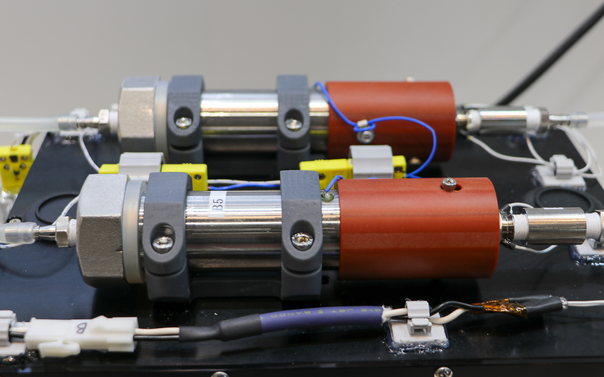 黒箱の上にある筒状の機械の中にCO2吸着フィルタが格納されていて、空気が透明チューブを通ってCO2吸着フィルタを通過する