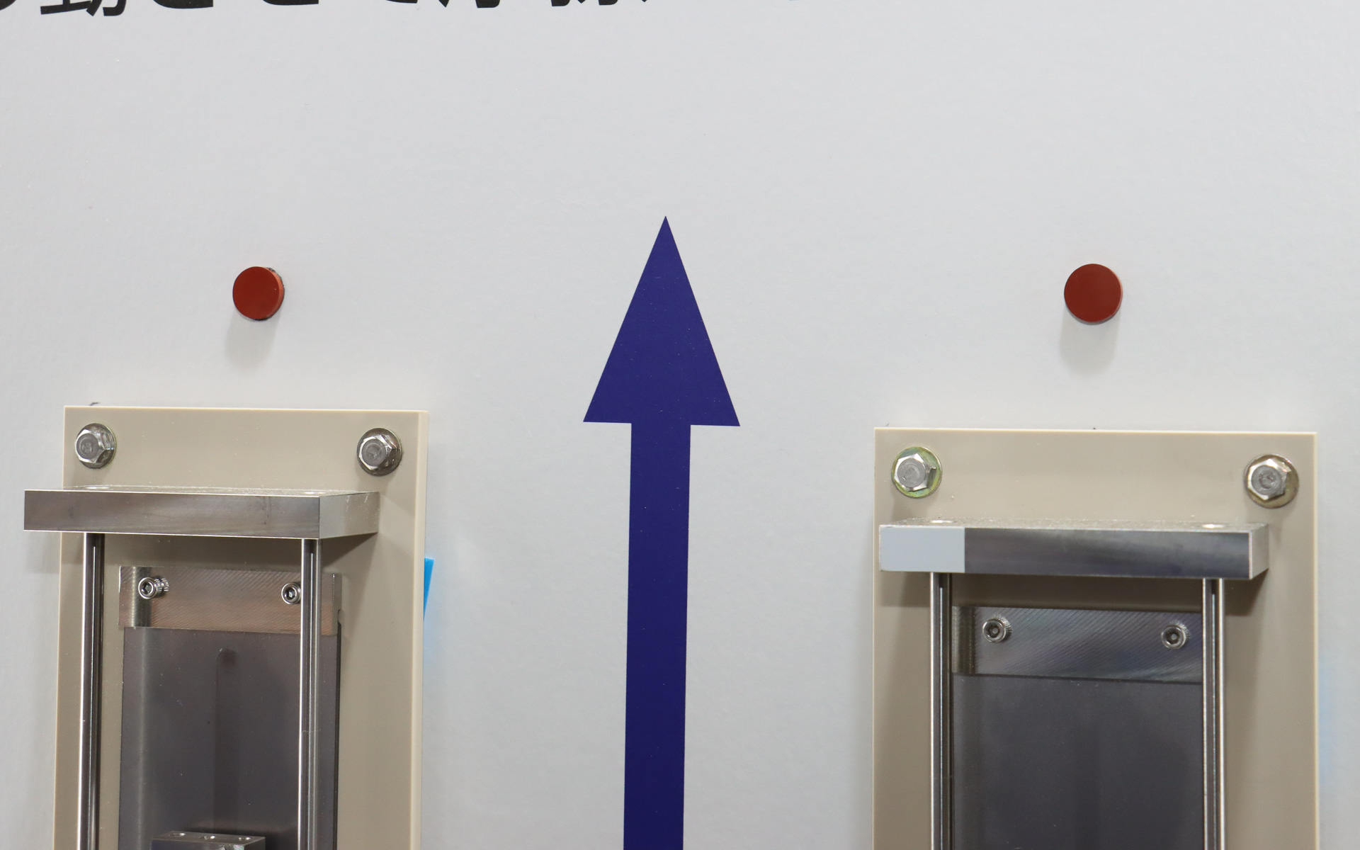 鉄板の上に貼り付けられているのが実際の従来ゴム（左）と自己潤滑ゴム（右）の実物。円盤形になっているゴムを半球状に押し付けて試験を行なう