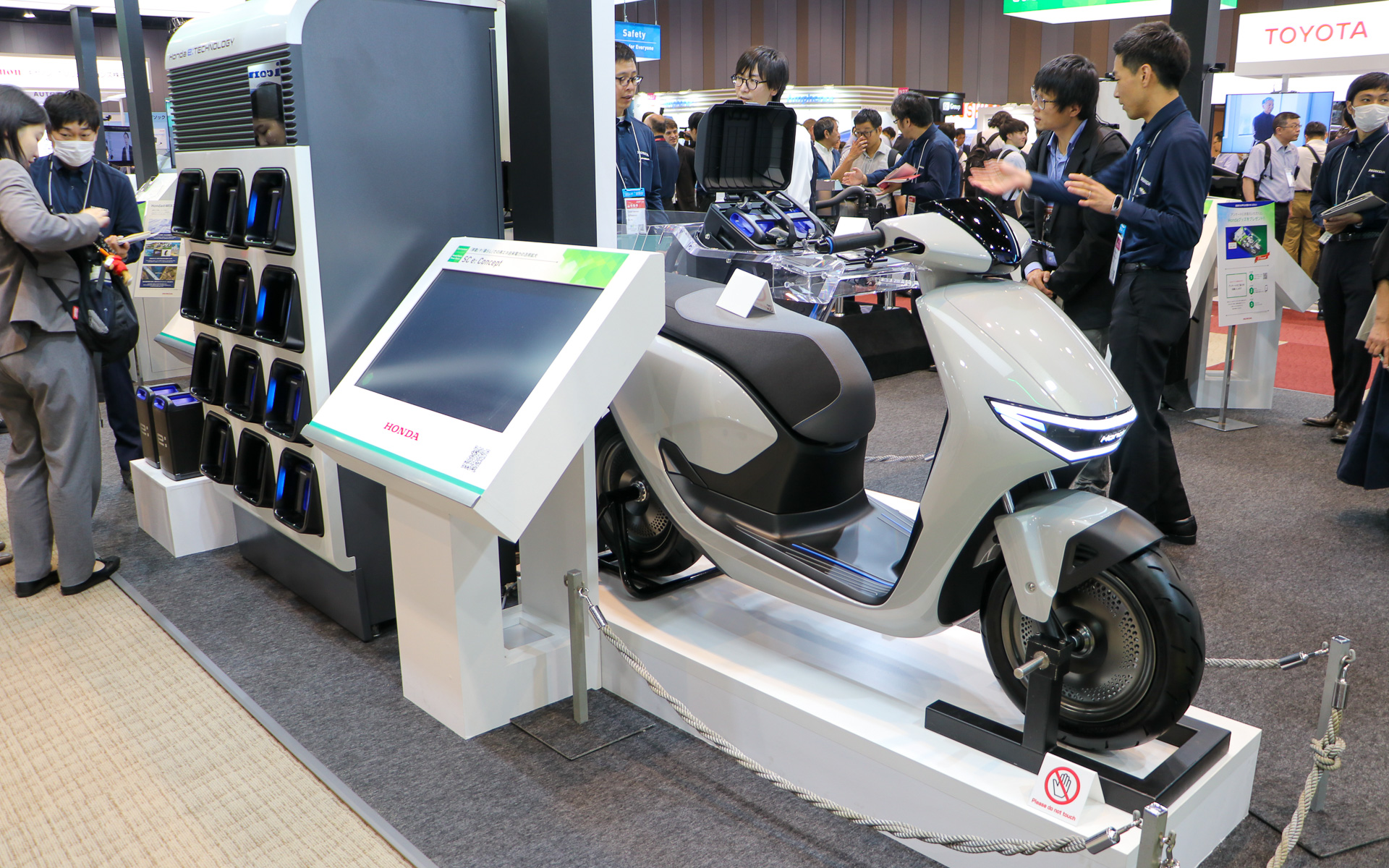 奥にはバッテリ交換ステーション「Honda Power Pack Exchanger e：」が設置され、手間にはEVバイク「SC e: Concept」が展示されている