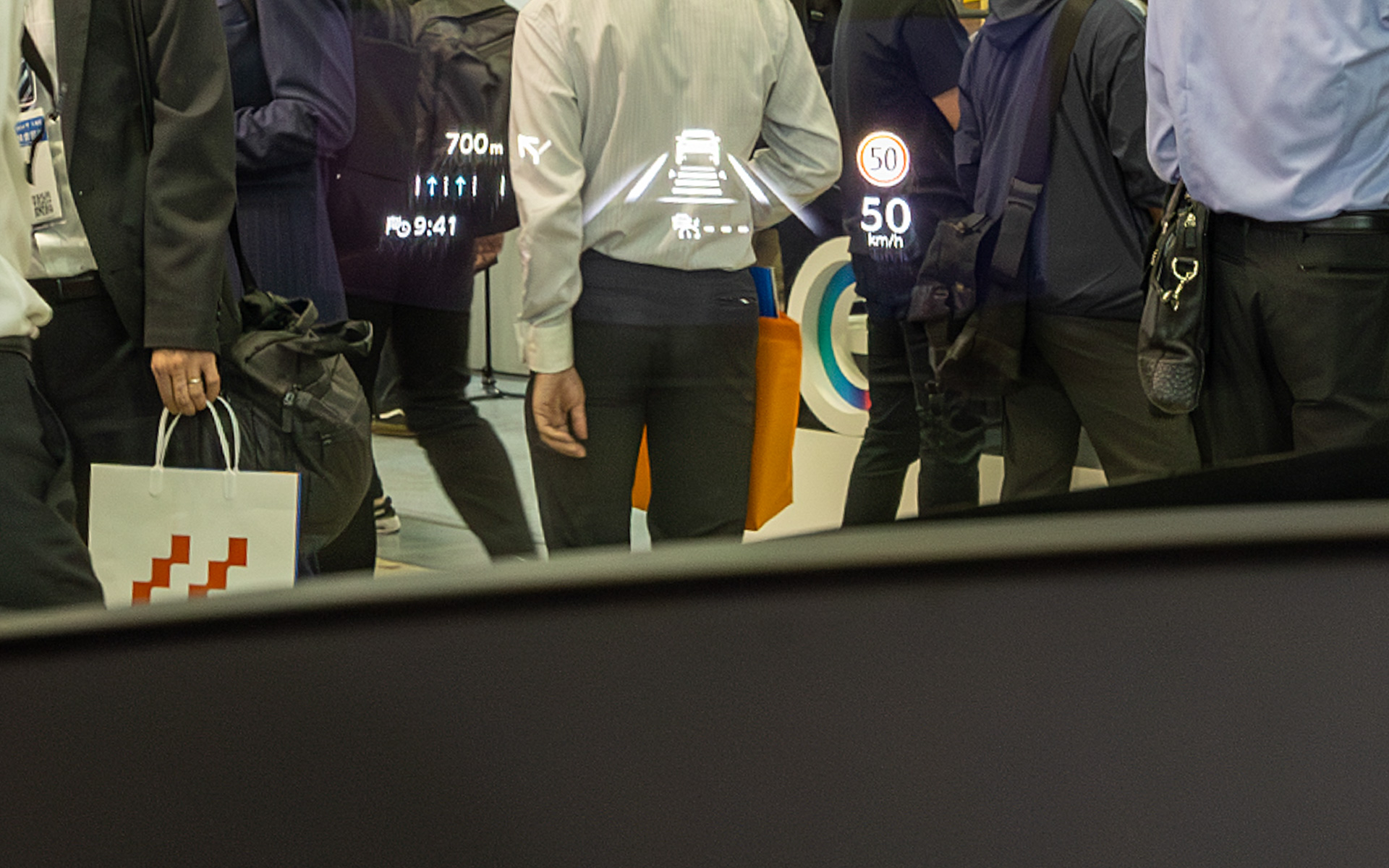 こちらはすでに市販車に使われているHUD。歩いている人の背中辺りに表示が写っている。十分見やすいがARヘッドアップディスプレイの表示と比べると視点の切り替えは必要