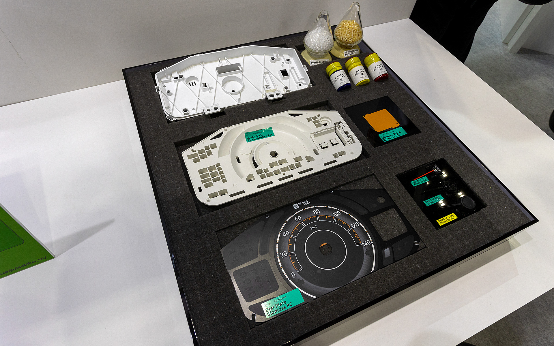 いちばん上が現在使用しているメーターケース。メーターは照明を使うのでケースはその反射に適した白色が基本。その下がバイオマス素材を使った試作品。若干色が付いている。もちろん塗装すればいいのだが、そうなるとコストが掛かるので素材で白色であることが重要という