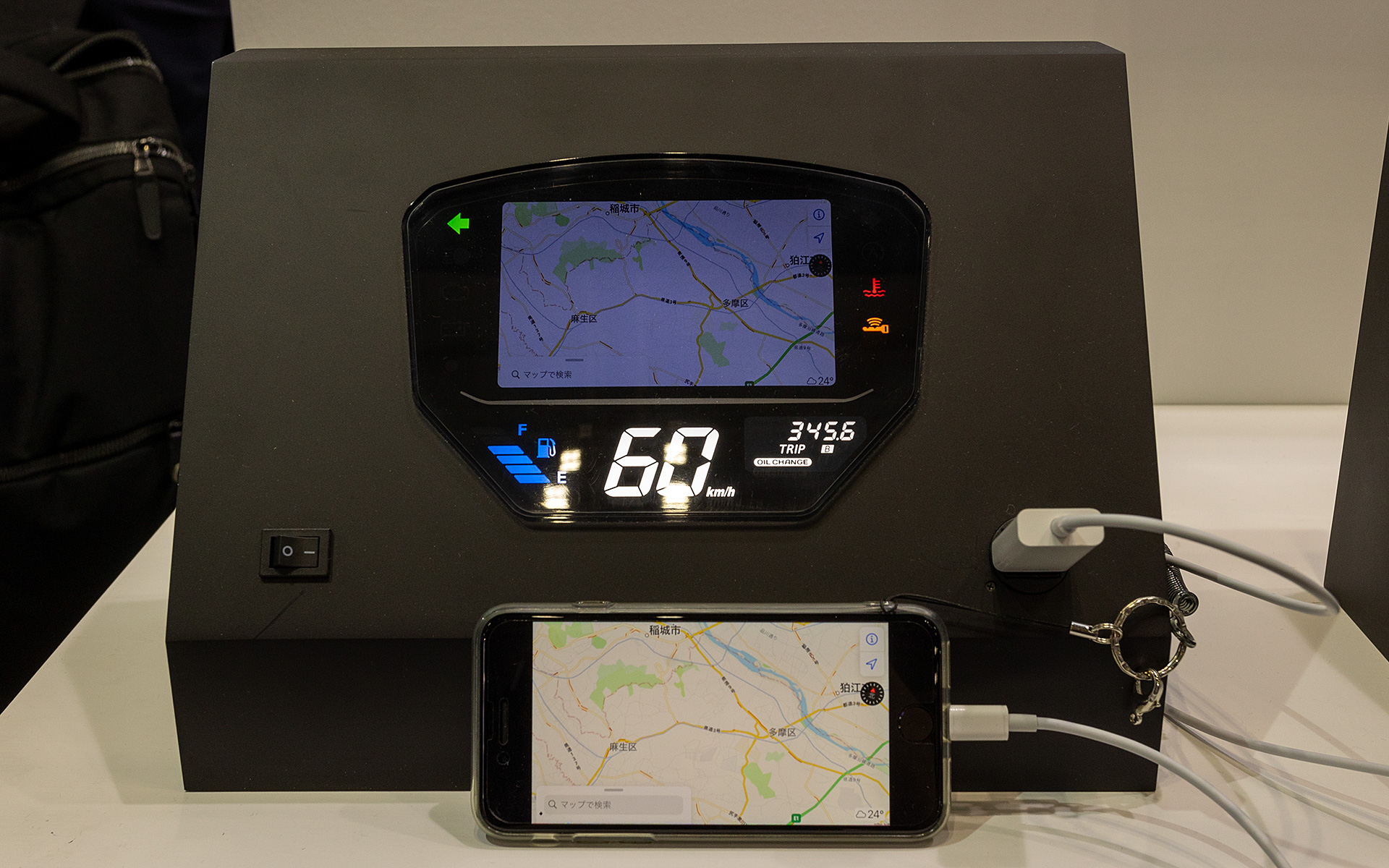 利便性を考慮したオートバイ用スマホ利用型メーターの展示。スマホの表示をメーター本体のディスプレイにミラーリングさせる。インドネシアなどアセアン地域向けの技術で、Bluetoothなど無線ではなくて有線でつなぐ方が好まれるという