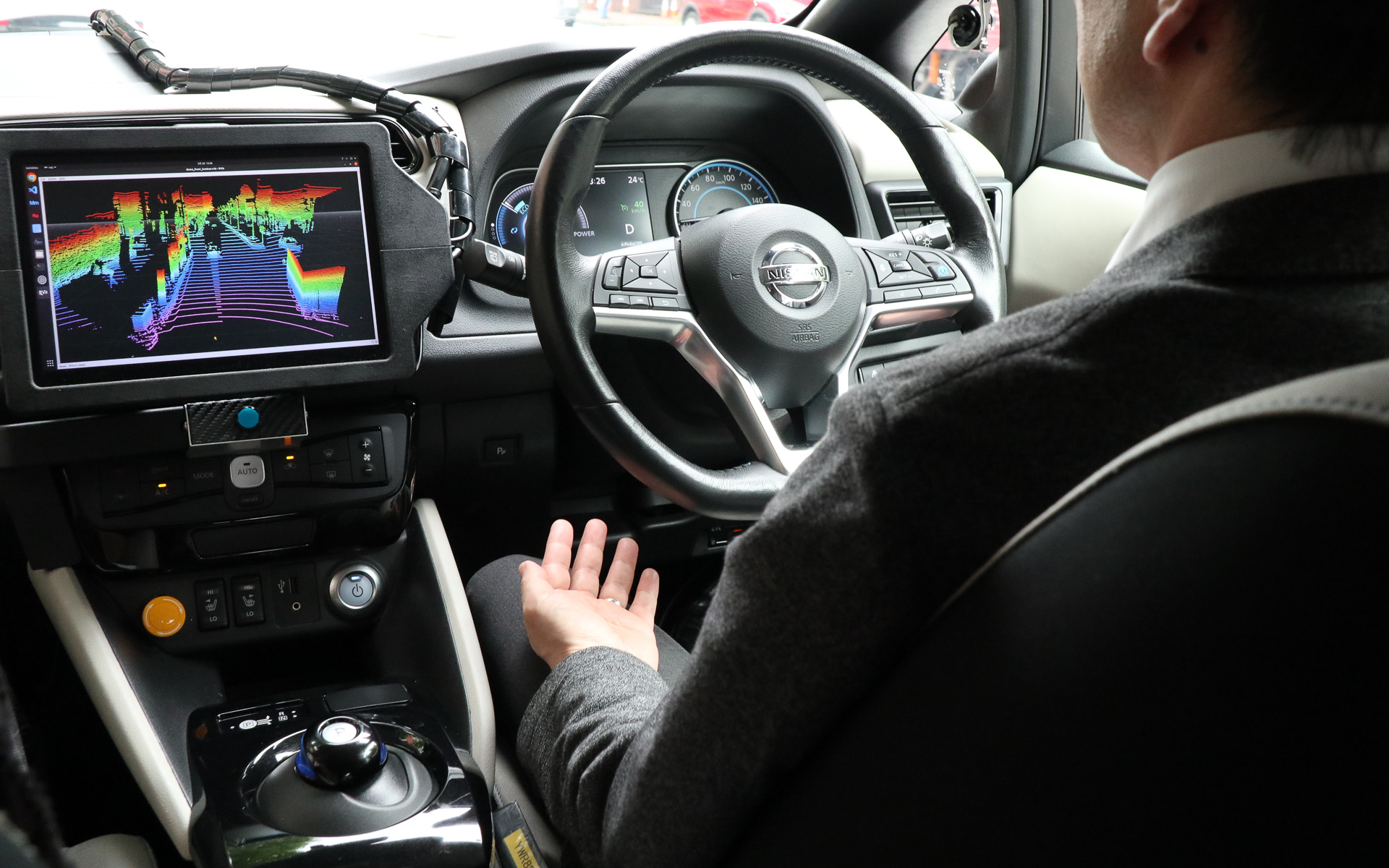 不測の事態で車両が停止した場合、遠隔監視する係員が回避する経路データを車両に送り、セーフティドライバーがインパネ中央にある承認ボタンを押して再スタートする