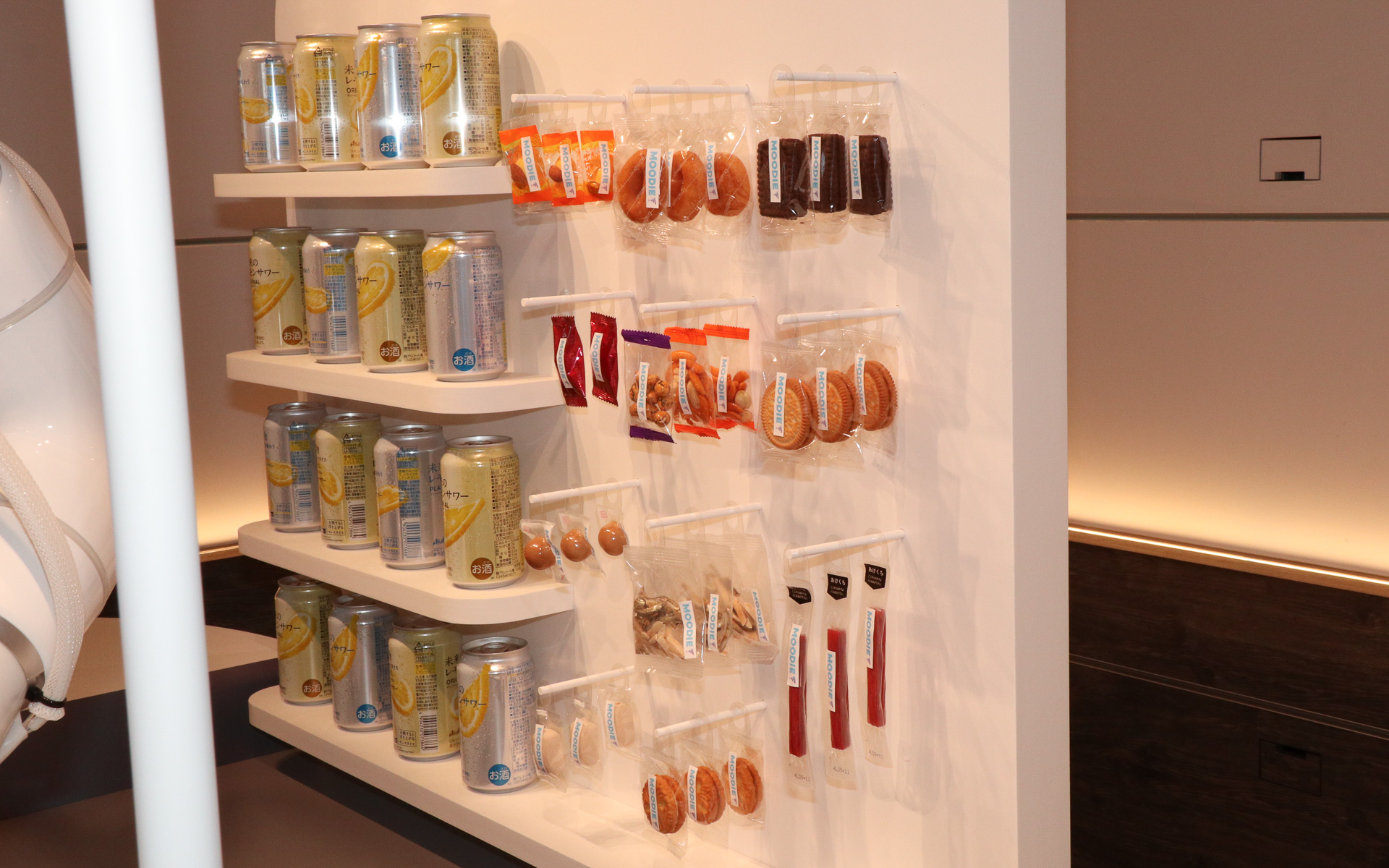 「未来のレモンサワー」に合うチーズやセミドライソーセージ、甘いドーナツやクッキーなどを多彩に用意。写真では「しくしく」気分の体験者に「お肉を食べて元気出して」とセミドライソーセージをプレゼントしている