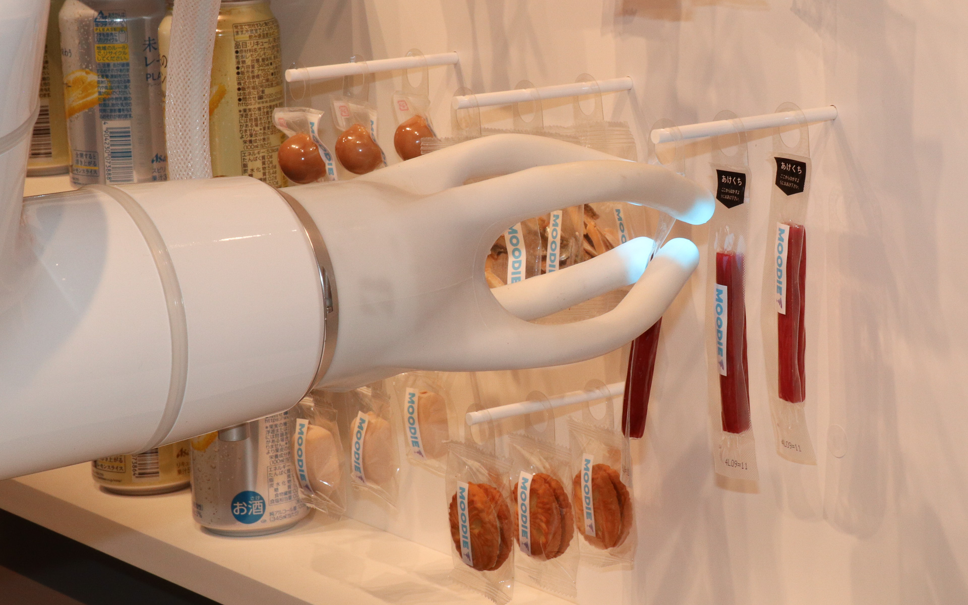 「未来のレモンサワー」に合うチーズやセミドライソーセージ、甘いドーナツやクッキーなどを多彩に用意。写真では「しくしく」気分の体験者に「お肉を食べて元気出して」とセミドライソーセージをプレゼントしている