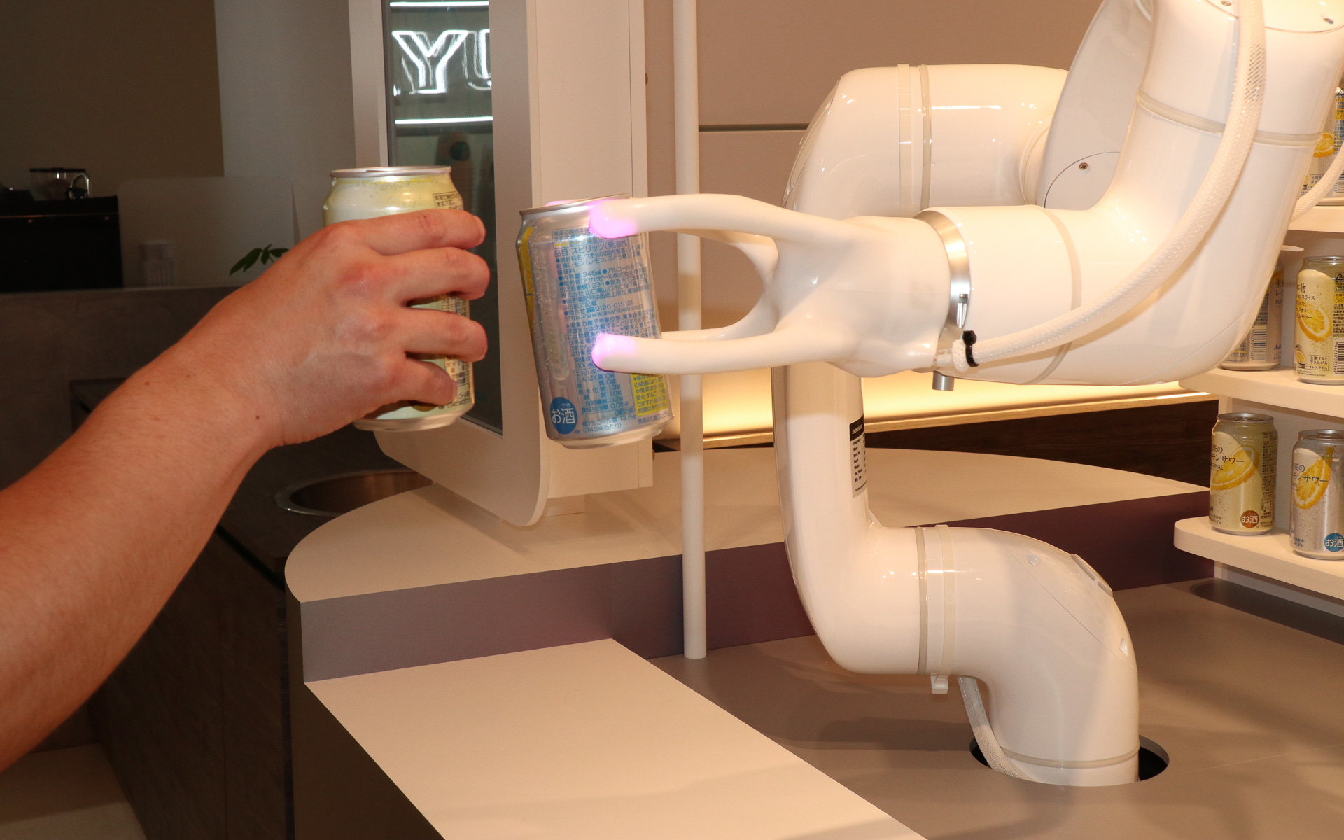 今回の展示は準備期間が短かったため、アームはプログラムに書き込まれた内容どおりに動作する設定。乾杯と聞いた体験者がアームの動きに合わせて缶を当てにいくと、アームにグイッと押し込まれて驚くような場面もあった