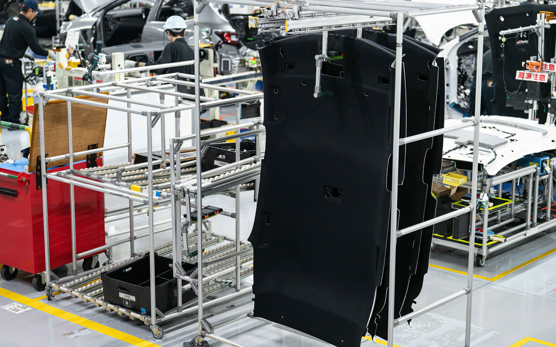 取り付ける部品がピッキングされている台車。奥の台車にはカラクリ機構に乗った通い箱が見える