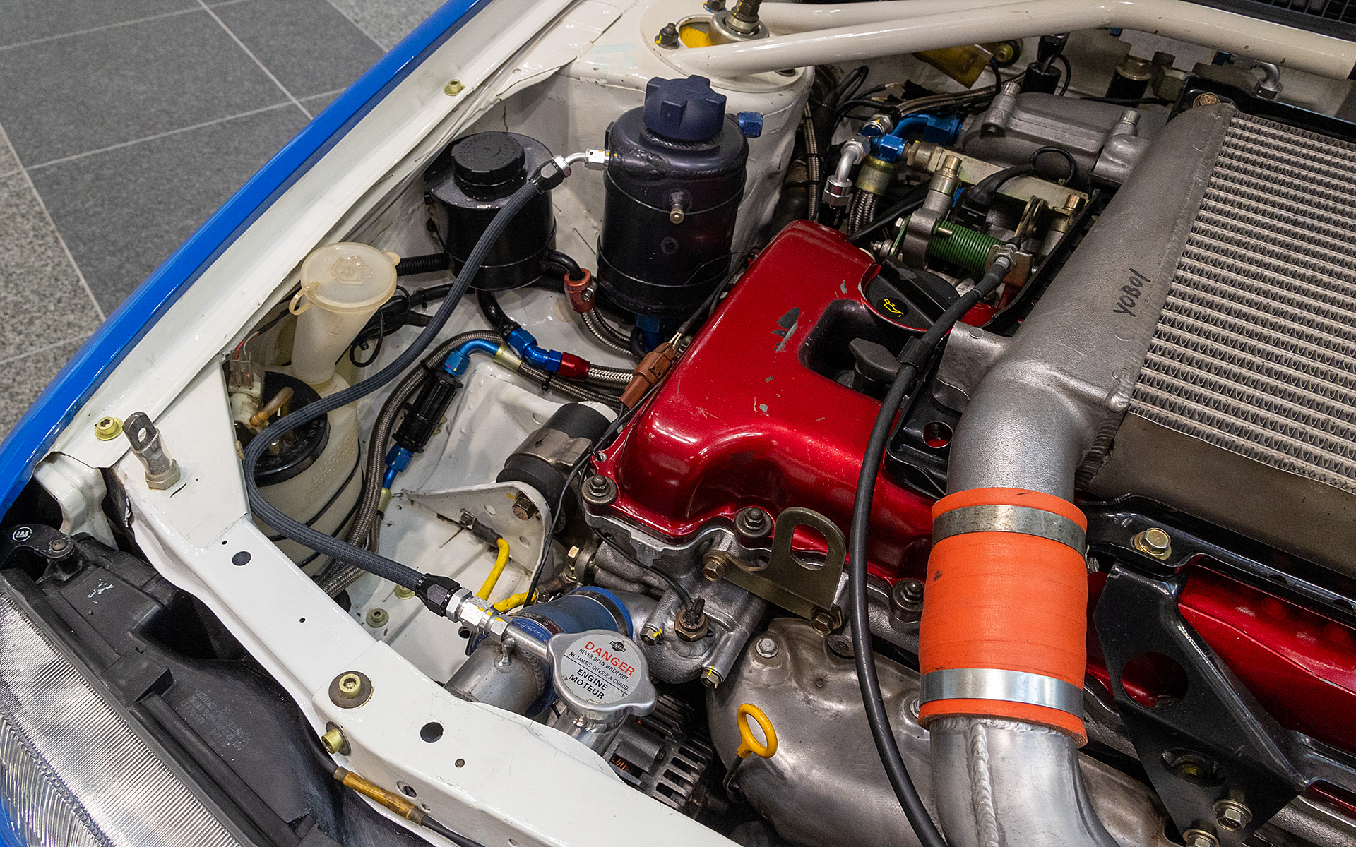 リザーバータンクのように見えるがニップルの数からクーラントに混じったエアを分離させるエア抜きタンクと思われる。ラジエターキャップからのホースも強化品に変えてある