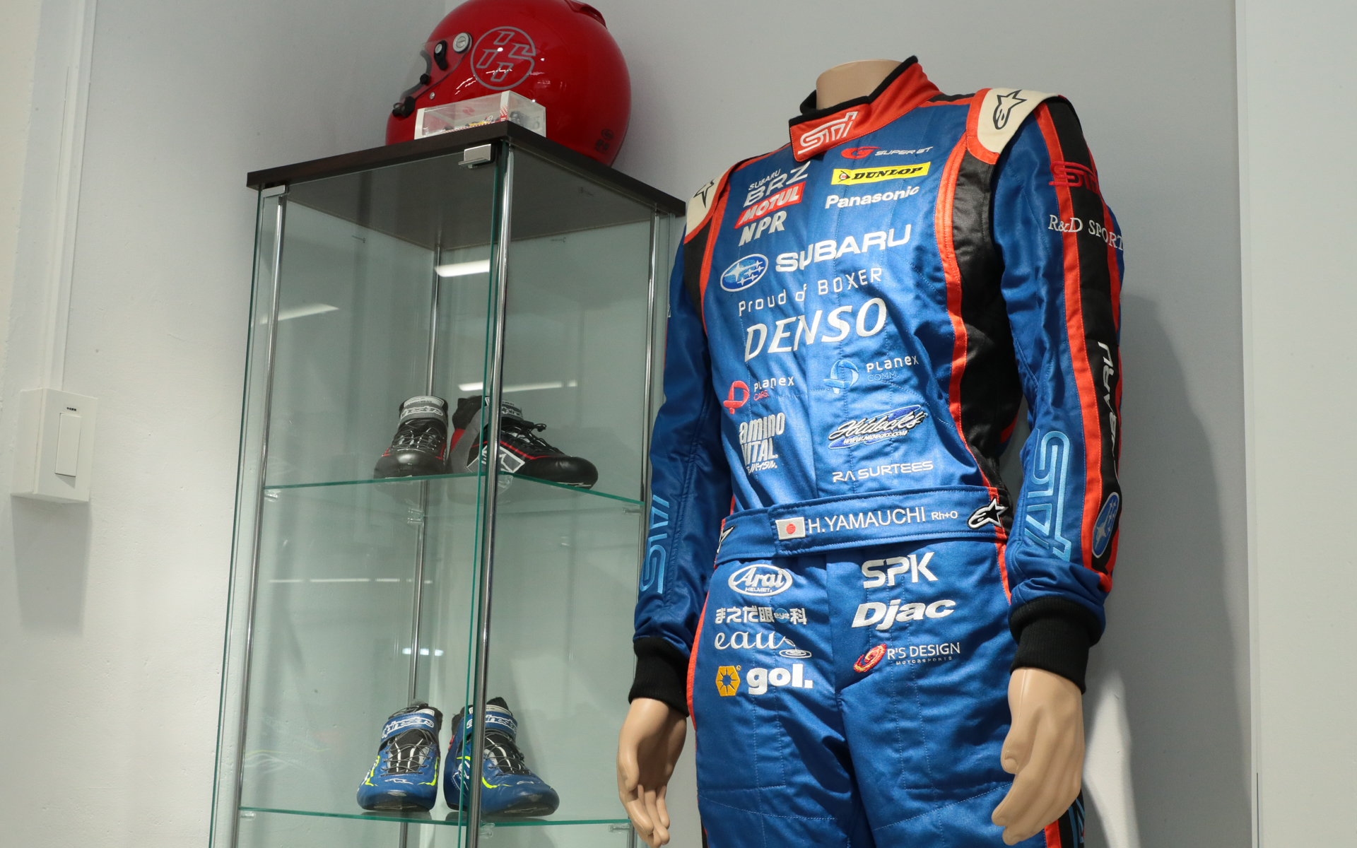 モータースポーツショールームには、実際にレーシングドライバーが着用したスーツやシューズなども展示してあった