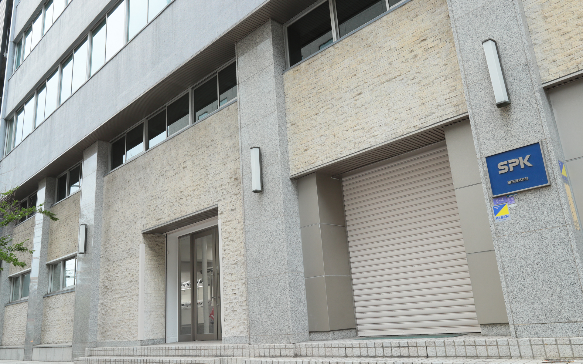 「モータースポーツショールーム」「シミュレーターラボ」の入口（中央のガラスの扉）