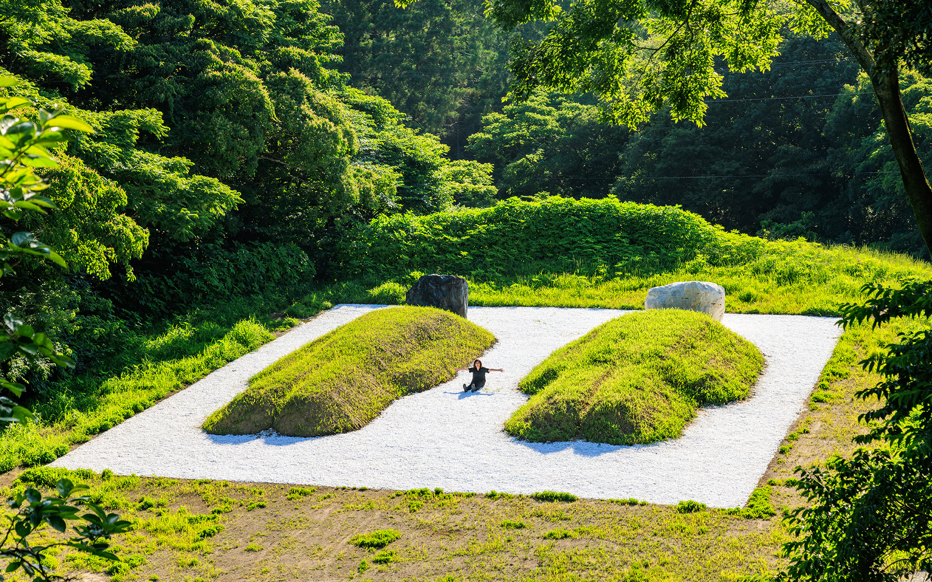 衝撃を受けたアート、島袋道造さんの「ツチオとツチコ：55年後のBED PEACE」はとーっても大きくて、クルックフィールズのスタッフも一緒に土や石を盛ったりして手伝ったそう。真ん中に座ってみると、その大きさがよく分かりますね。最初は土がむき出しだったのが、だんだん草が生えてきて、この先も自然にまかせていくそうです