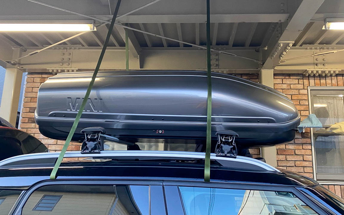 ルーフボックスとキャリアの取り外しは大人2人でも大変なので、駐車場の天井にベルトをつけ、持ち上げておきながらキャリアの付け替え作業を行ないました。これはなかなかナイスアイディアでした（笑）