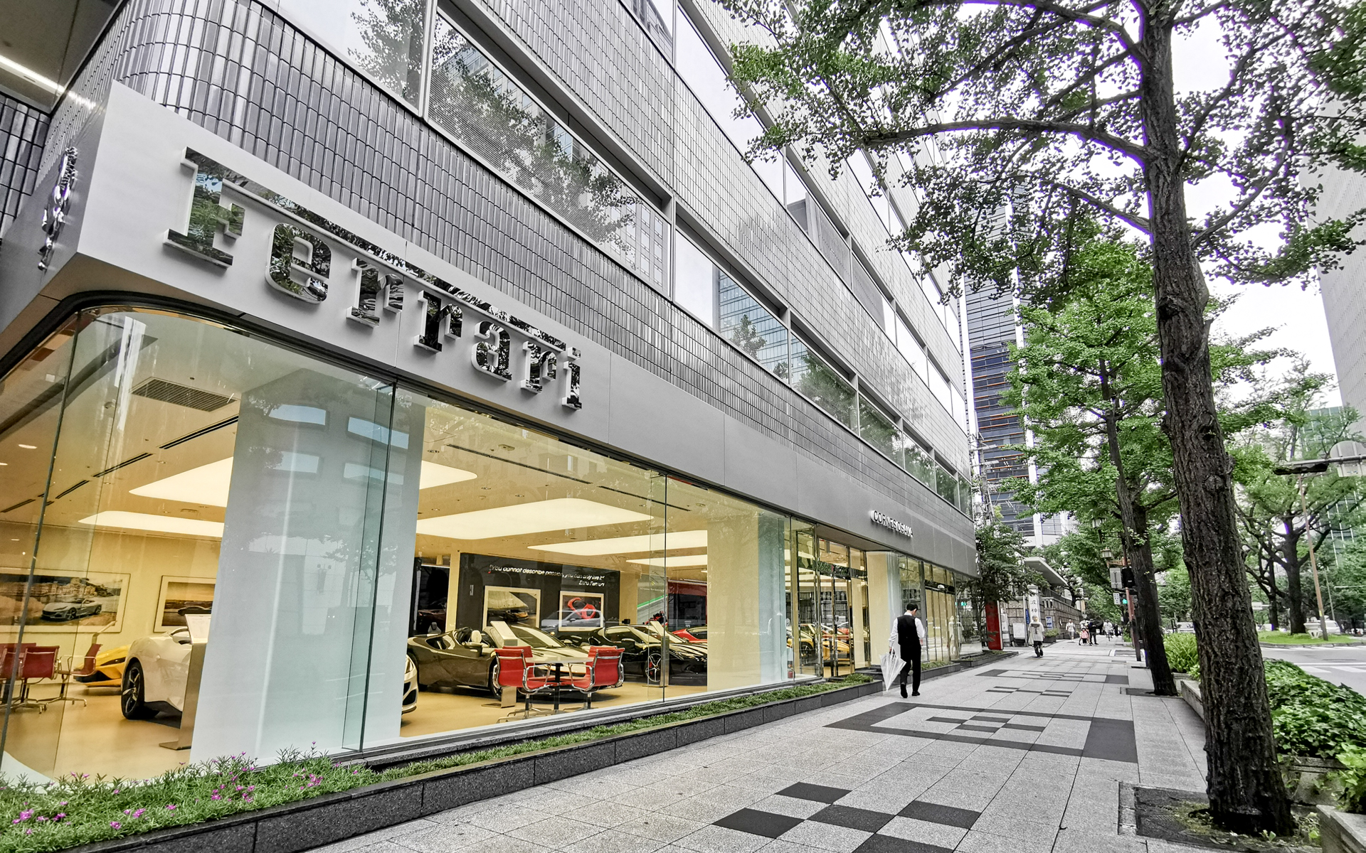 新車を販売する「コーンズ大阪ショールーム」の隣にある難波神社の向こう側に今回オープンした「コーンズ大阪 プレオウンドショールーム」 がある。距離にして約50～60m