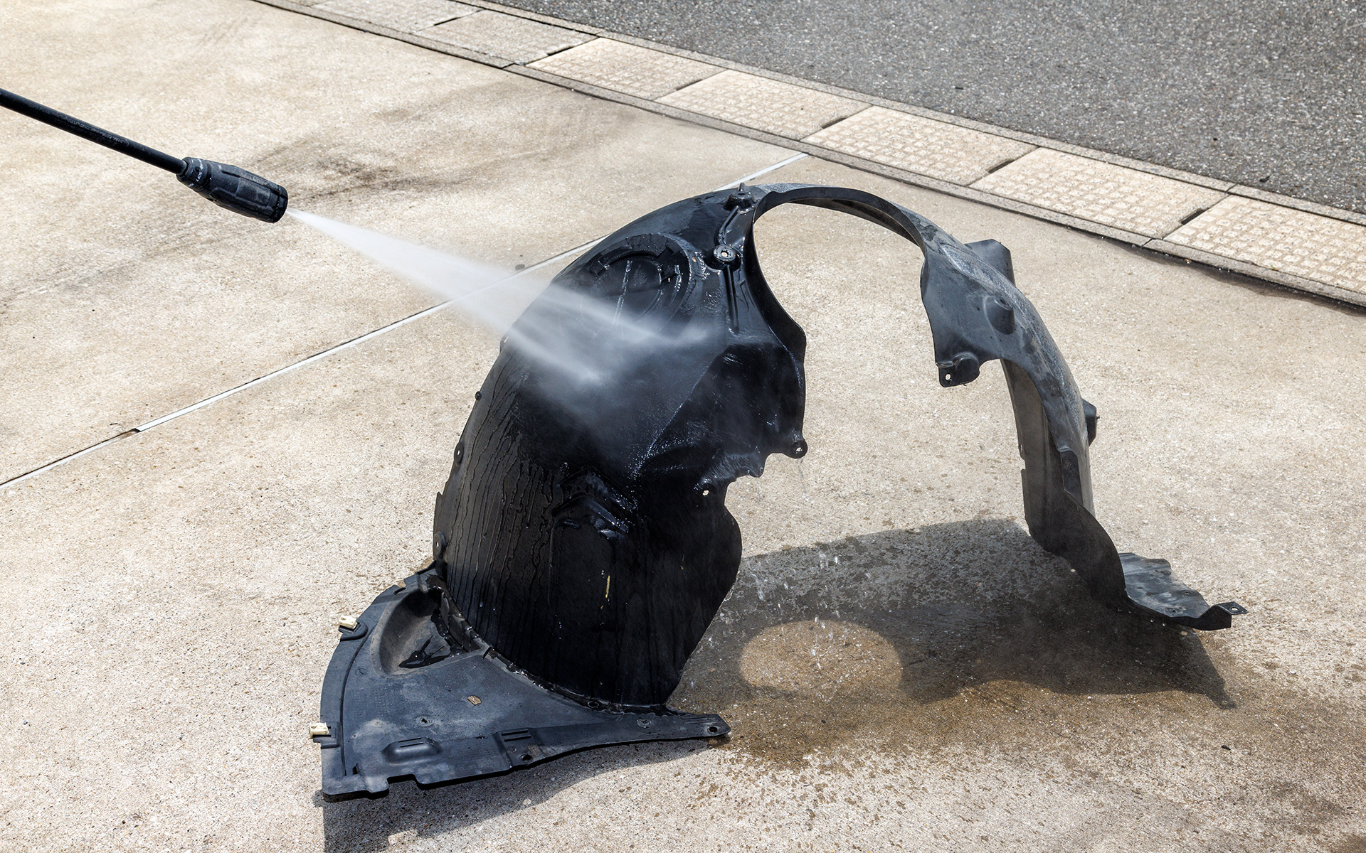 まずはホイールハウス内側にあるインナーフェンダーを外し、糊がしっかりと着くように洗浄。この洗浄とともにインナーフェンダーを外した際、フロアに小石や泥などが落ちていることが確認でき（写真右）、普段の洗車ではなかなか手が届かない箇所がきれいになるというのもうれしいポイントの1つ