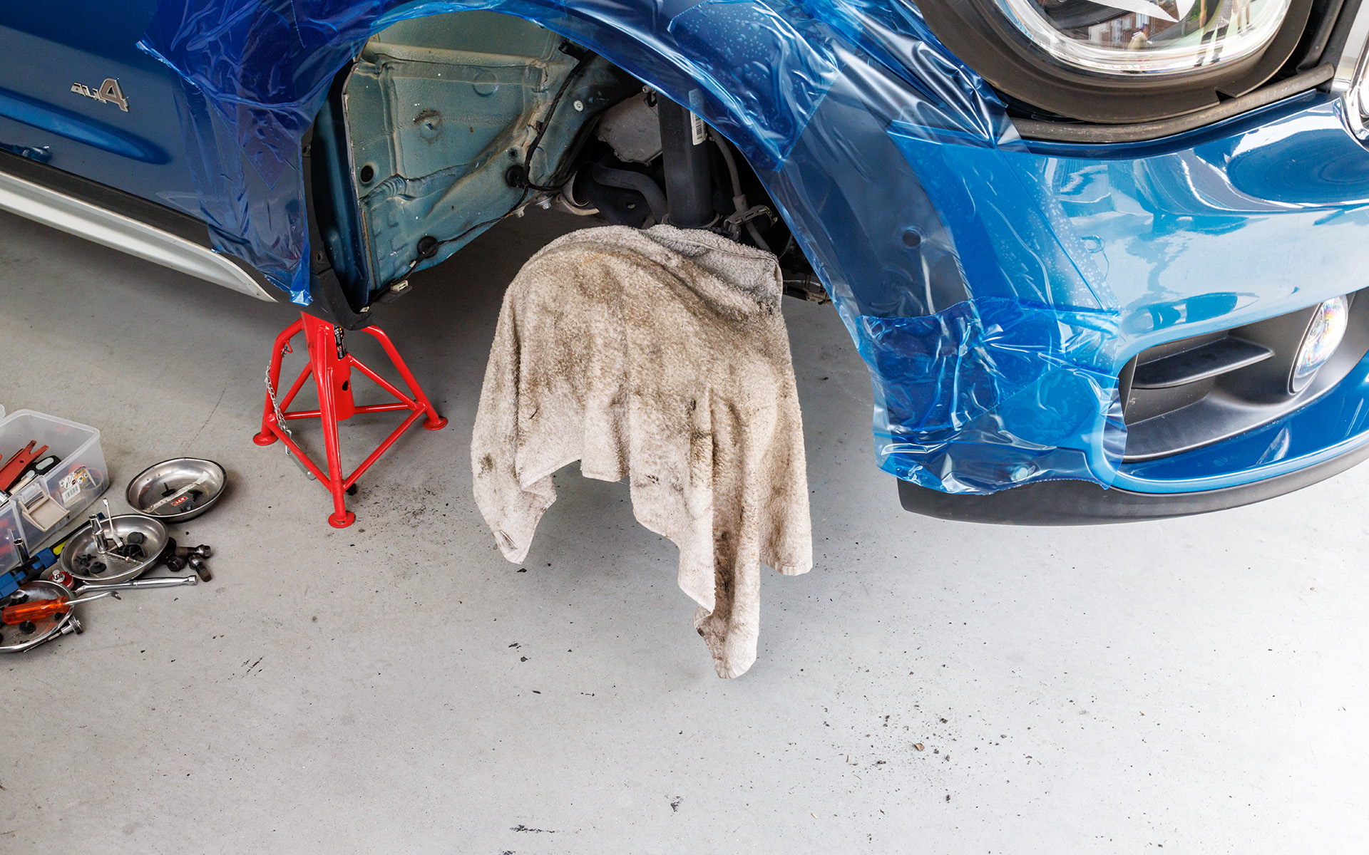 まずはホイールハウス内側にあるインナーフェンダーを外し、糊がしっかりと着くように洗浄。この洗浄とともにインナーフェンダーを外した際、フロアに小石や泥などが落ちていることが確認でき（写真右）、普段の洗車ではなかなか手が届かない箇所がきれいになるというのもうれしいポイントの1つ