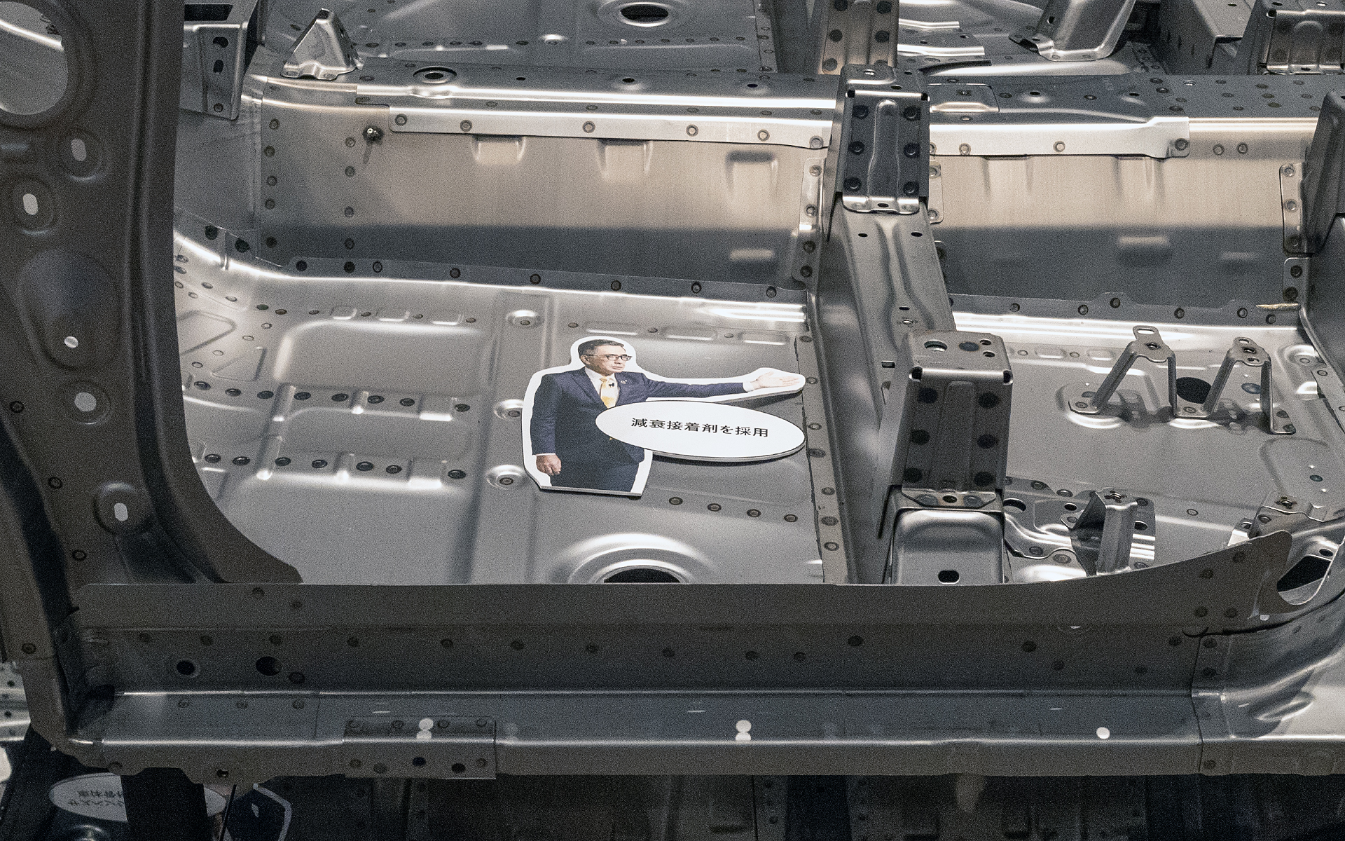 鈴木社長の写真を使ったユニークな展示。指している部位にはボディのなかで最も強度のある1470MPaの高張力鋼板が使われている