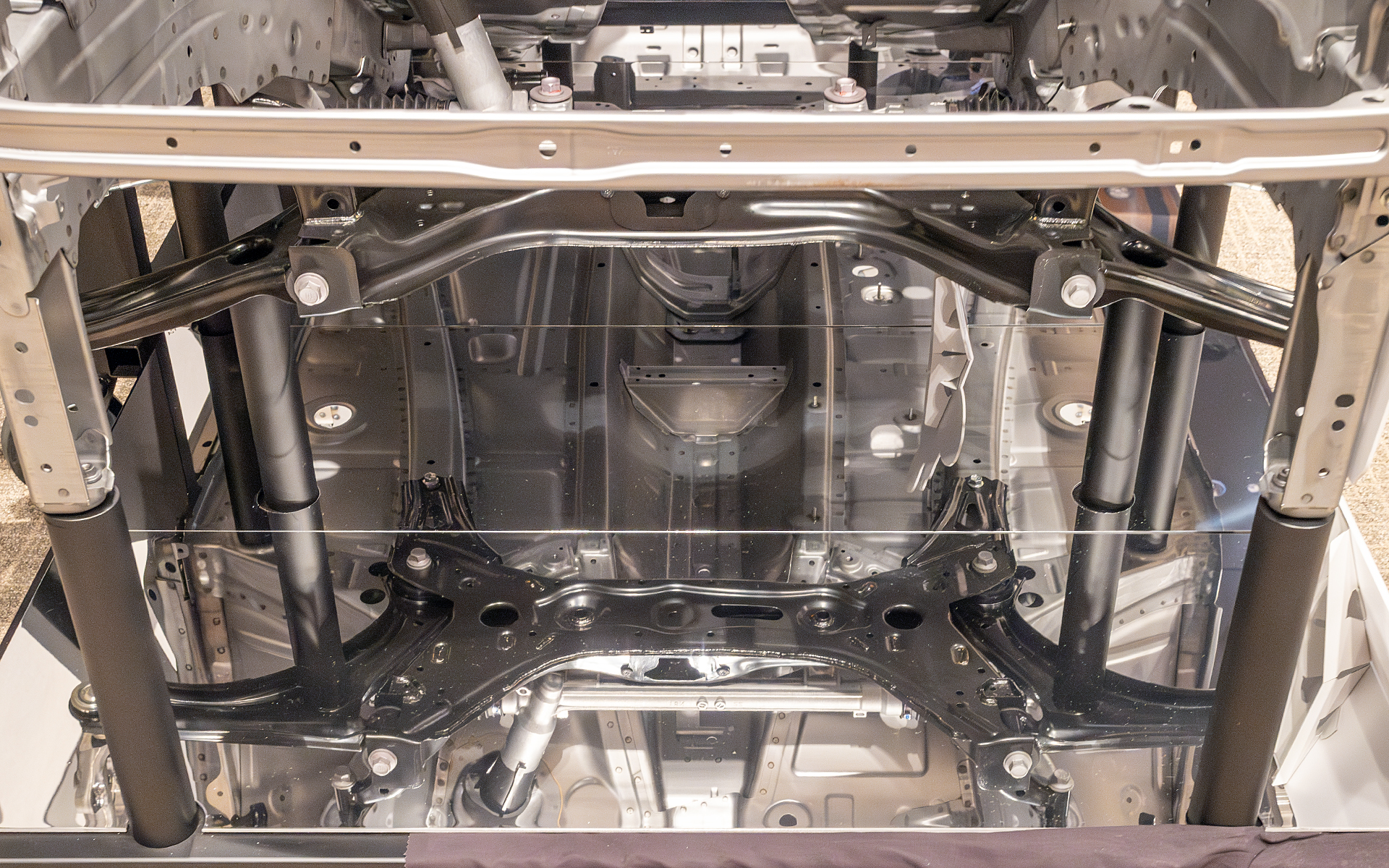 サスペンションフレームを車体骨格の一部として使えるような構造としている