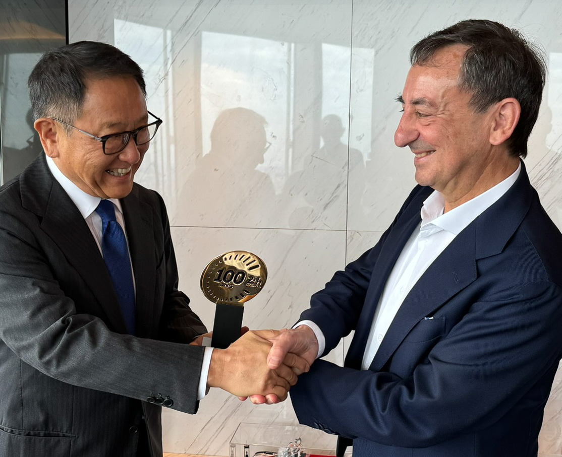 笑顔でがっちり握手する2人