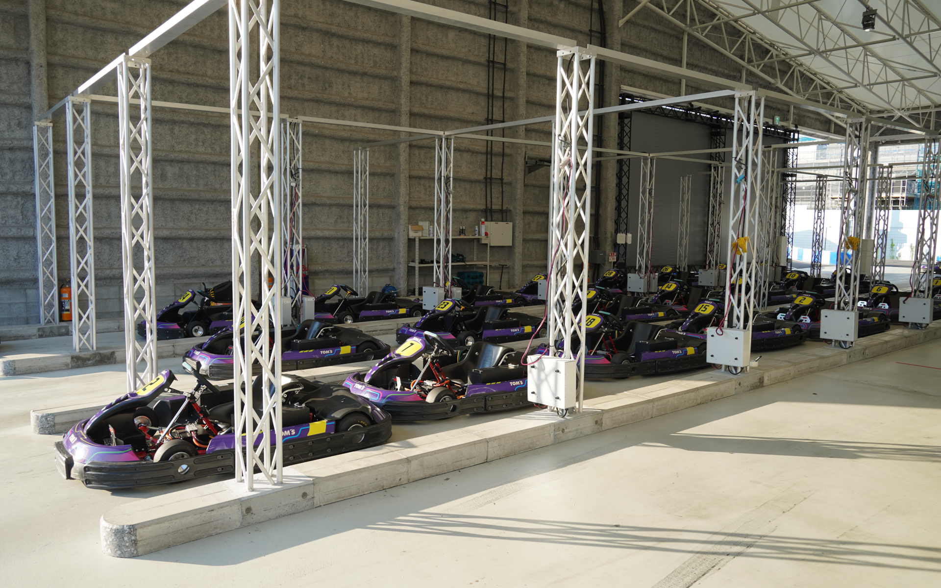 ピットに止まる電動カートにはトムスのロゴがある